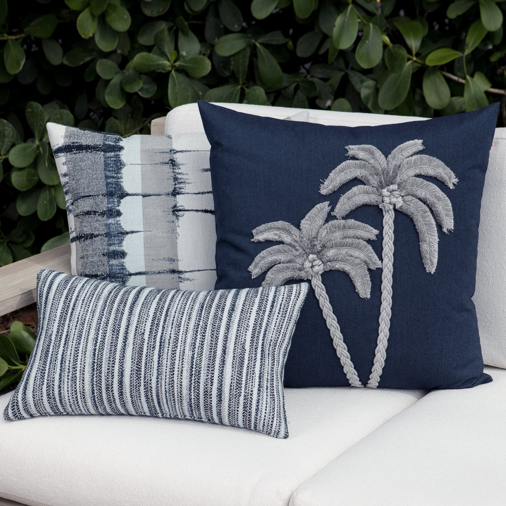Luxury indigo and gray modern patterned square pillow on a outdoor sofa styled for hospitality suites, featuring solution dyed performance fibers for hospitality and commercial spaces