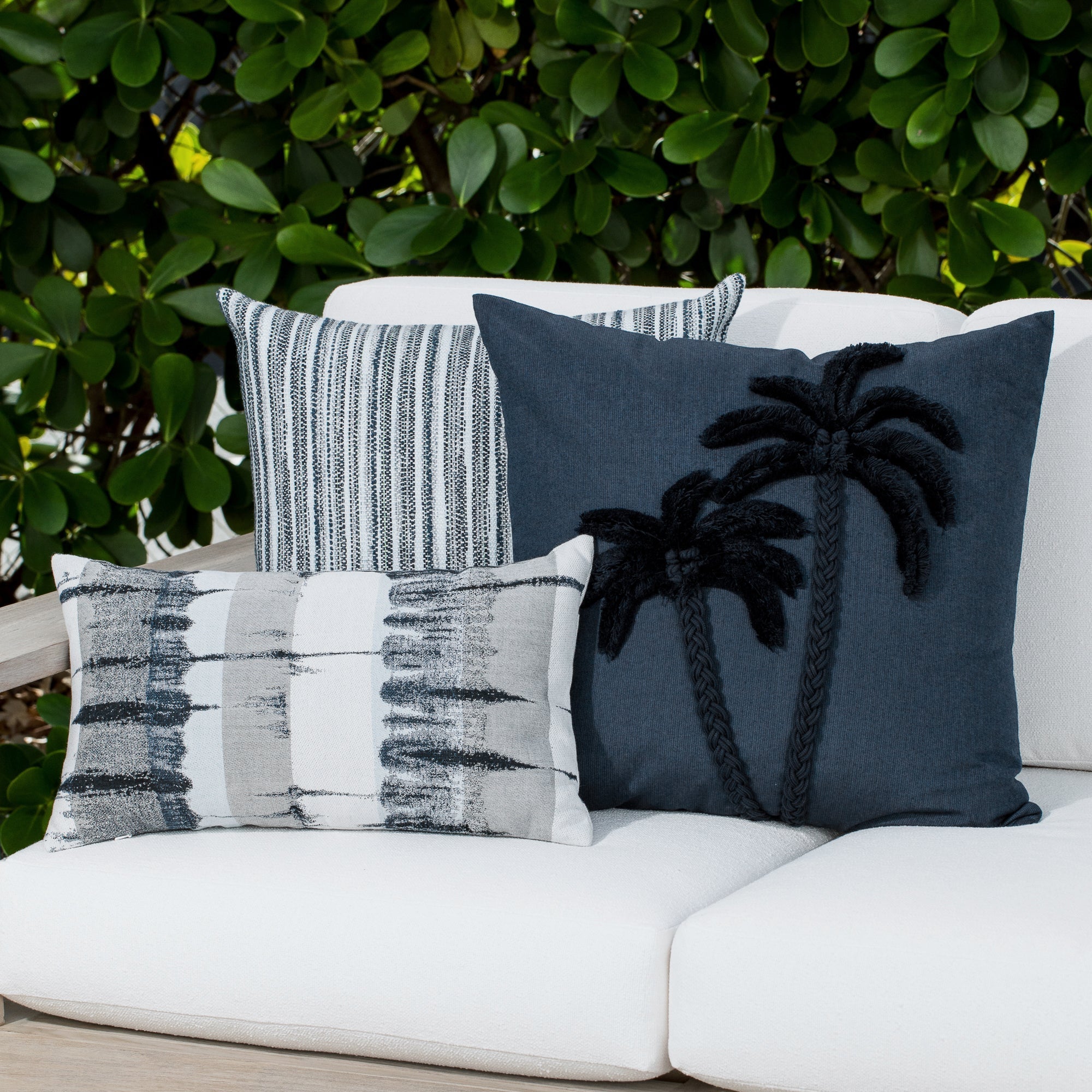 Luxury indigo and gray modern patterned square pillow on a outdoor sofa styled for hospitality suites, featuring solution dyed performance fibers for hospitality and commercial spaces