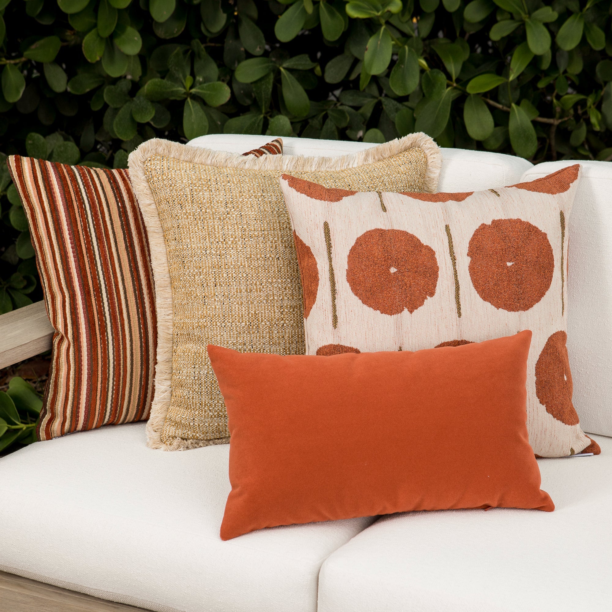 Outdoor image of pillows in Artful circle motif in papaya orange on outdoor-safe fabric – Solstice Papaya by Elaine Smith