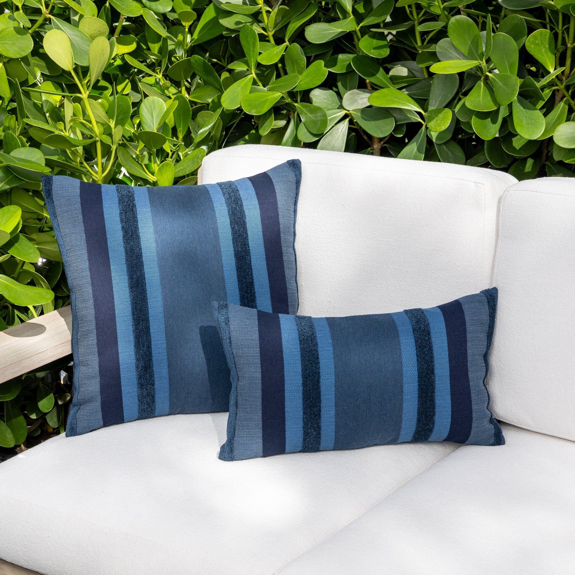Luxury blue striped modern patterned accent pillow on a outdoor sofa, featuring commercial grade construction for luxury hotel and resort design