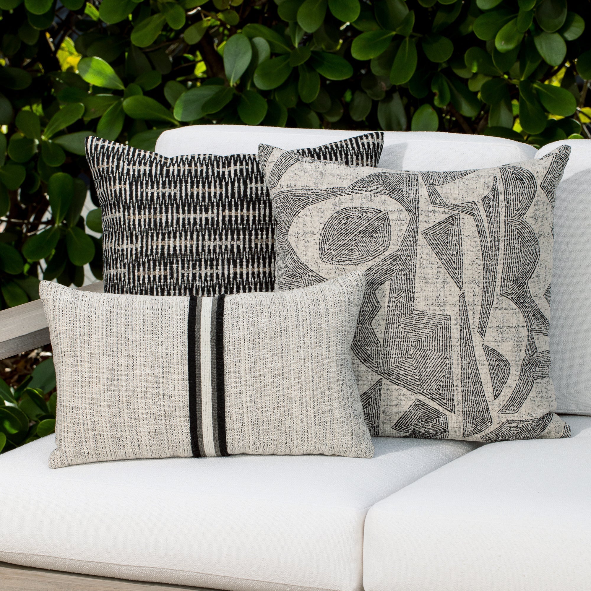 Luxury taupe textured woven decorative pillow on a outdoor sofa, featuring all weather performance construction for residential and commercial interiors