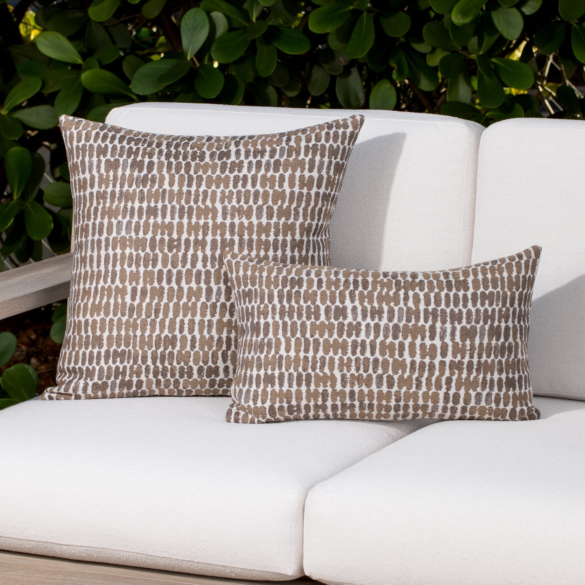 Luxury taupe and white two tone cushion on a woven outdoor sofa, featuring commercial grade construction for luxury hotel and resort design