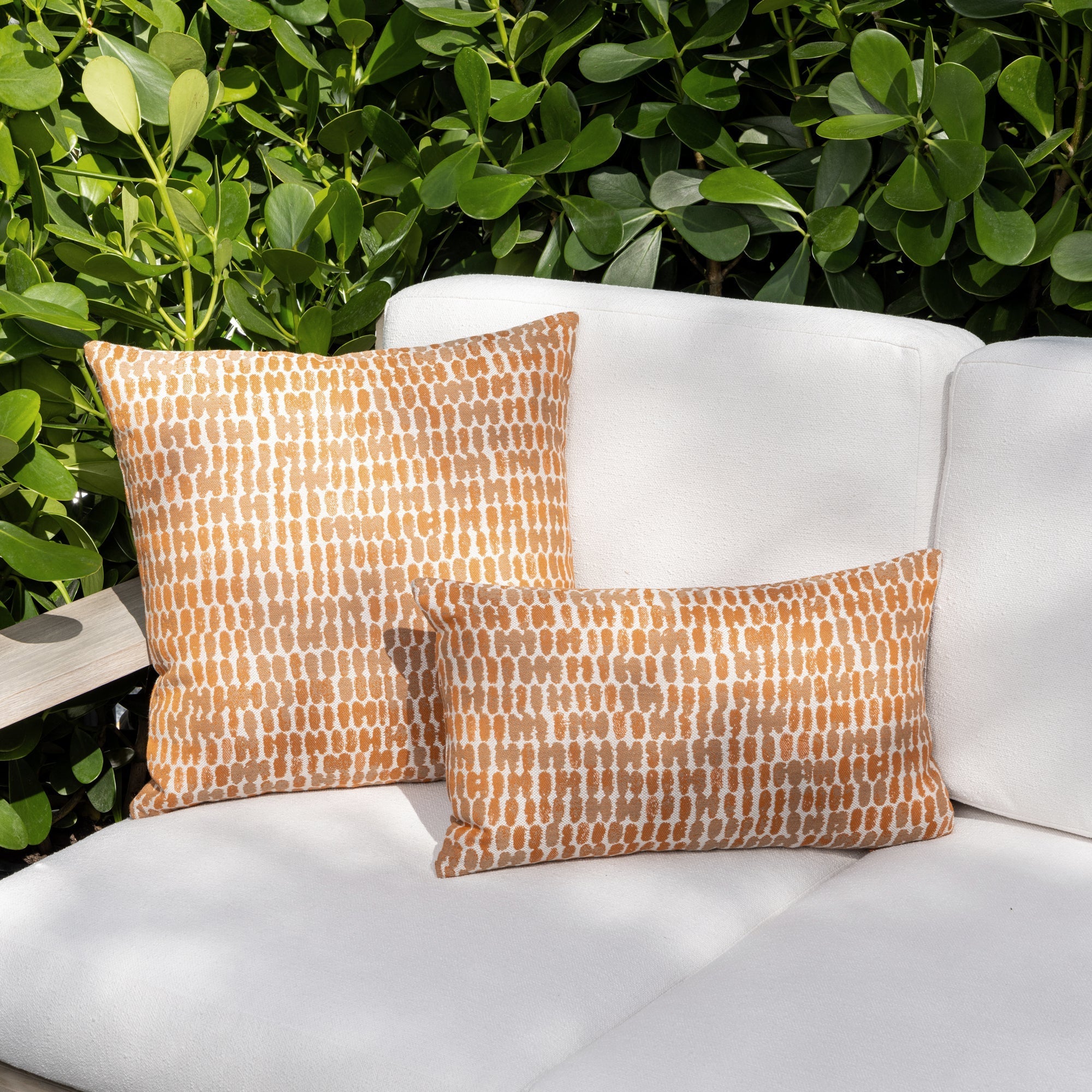 Luxury orange ombre striped modern patterned square pillow on a outdoor sofa, featuring weather resistant performance fabric for indoor and outdoor use by Elaine Smith