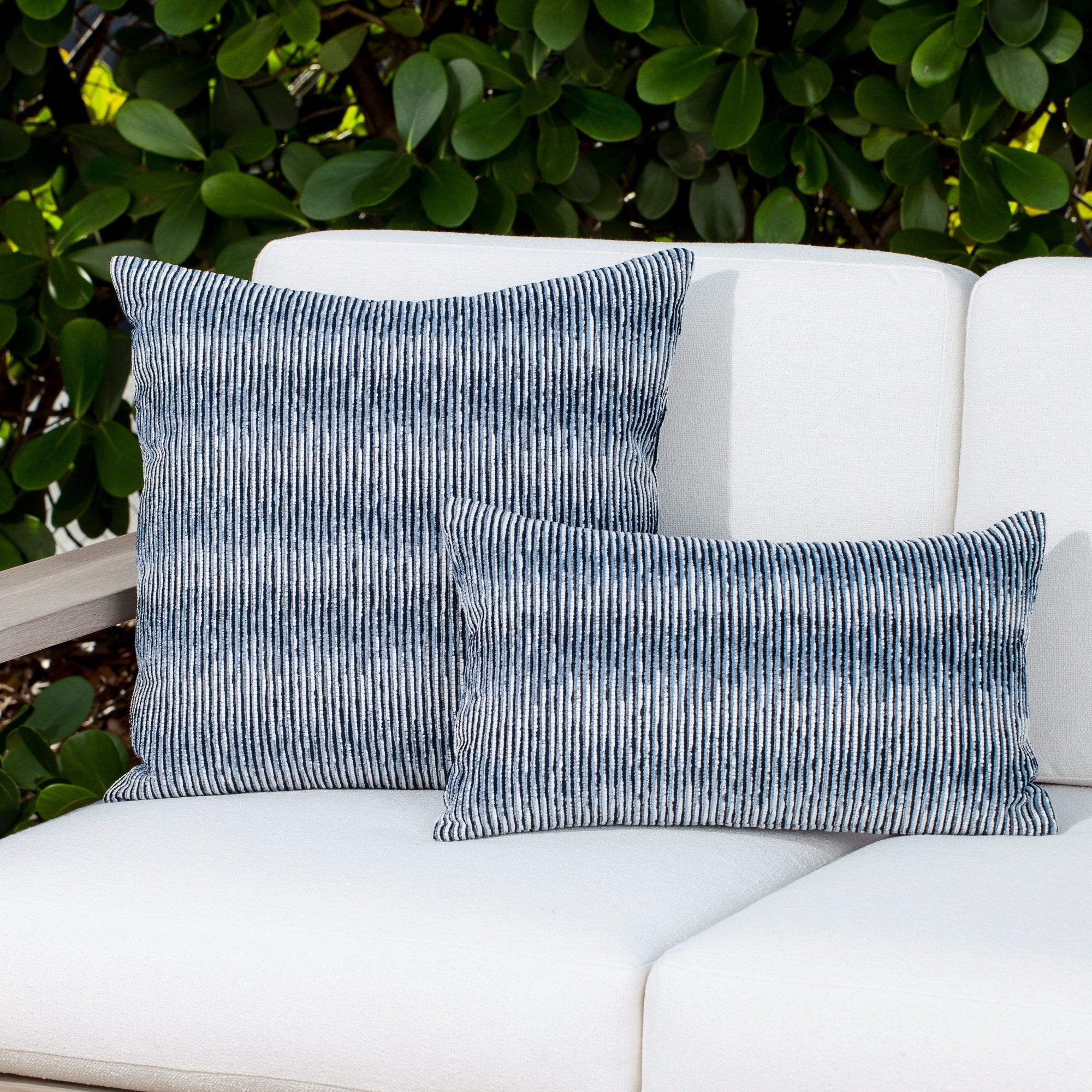 Luxury indigo subtle patterned decorative pillow on a woven outdoor sofa, featuring soft touch performance weave for residential and commercial interiors
