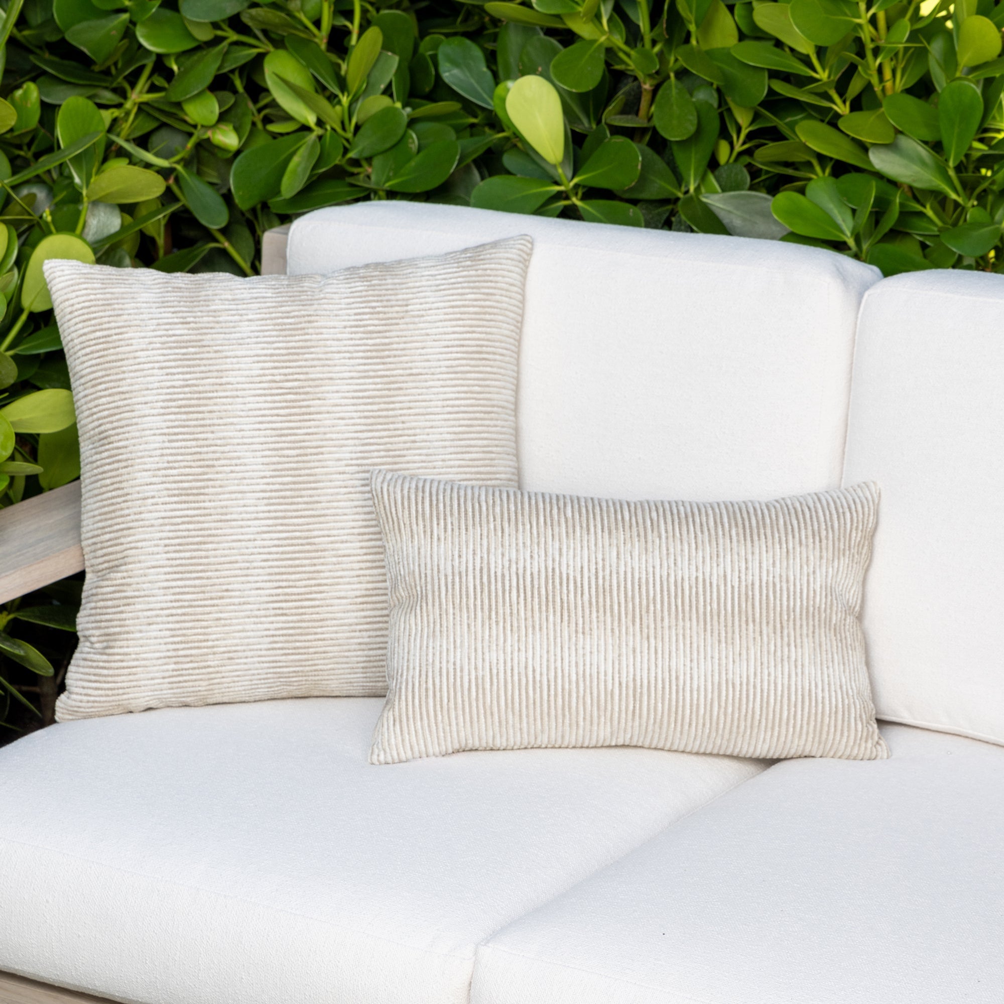 Luxury sand subtle patterned decorative pillow on a woven outdoor sofa, featuring soft touch performance weave for residential and commercial interiors