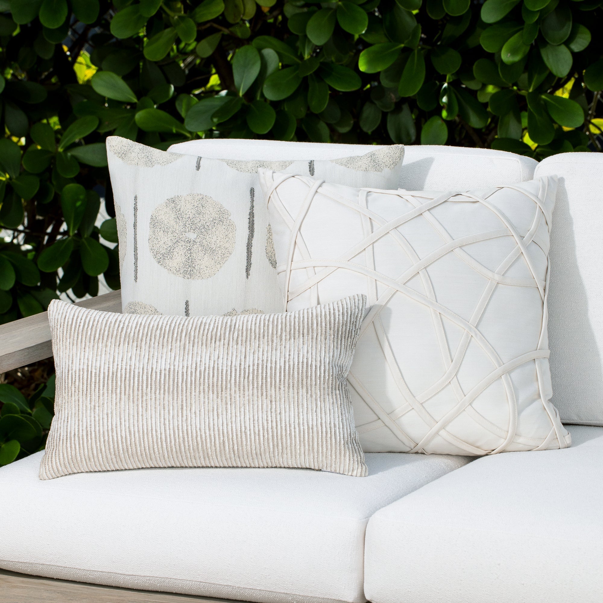 Luxury sand subtle patterned decorative pillow on a woven outdoor sofa, featuring soft touch performance weave for residential and commercial interiors