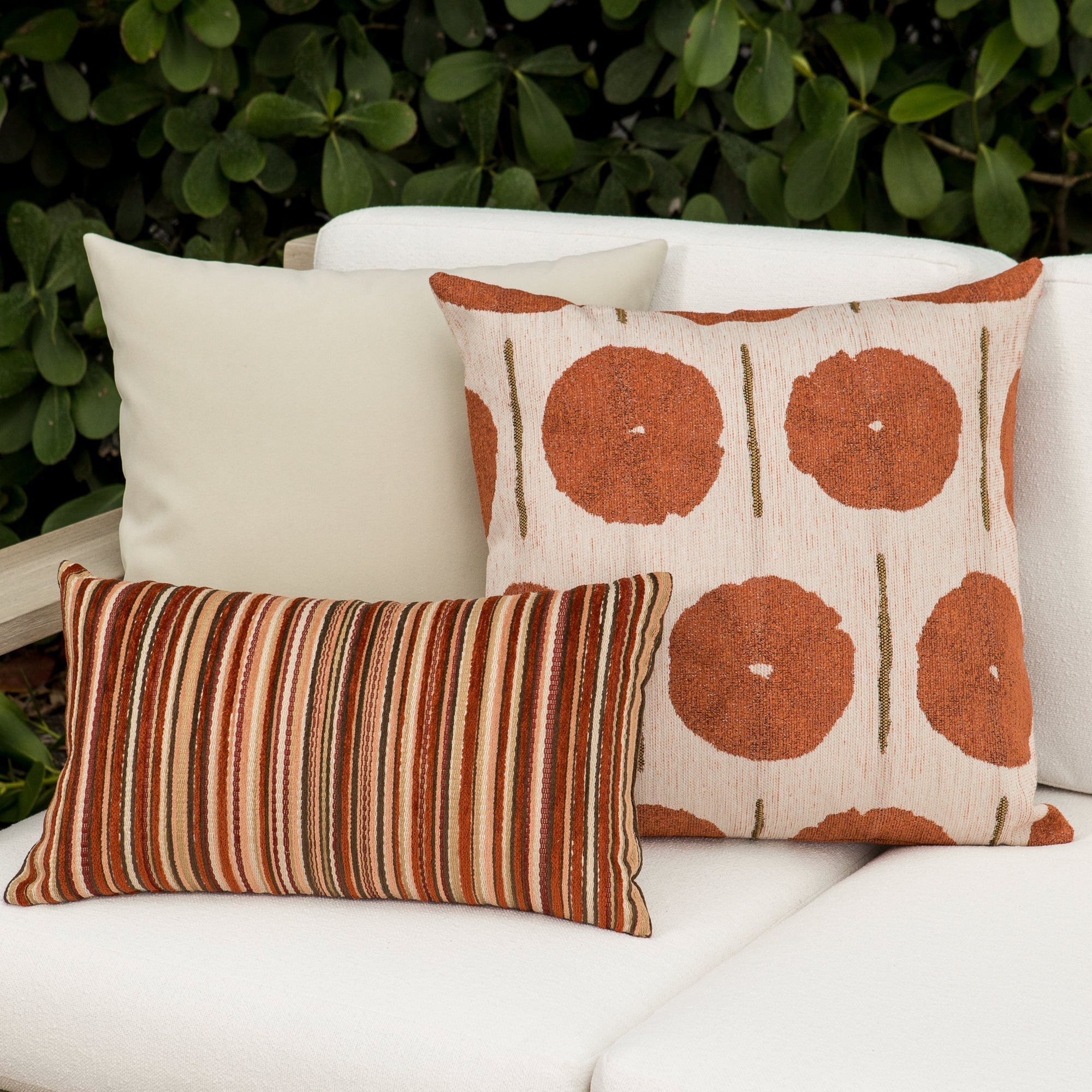 Luxury rust and cream geometric patterned accent pillow on a outdoor sofa, featuring commercial grade construction for luxury hotel and resort design