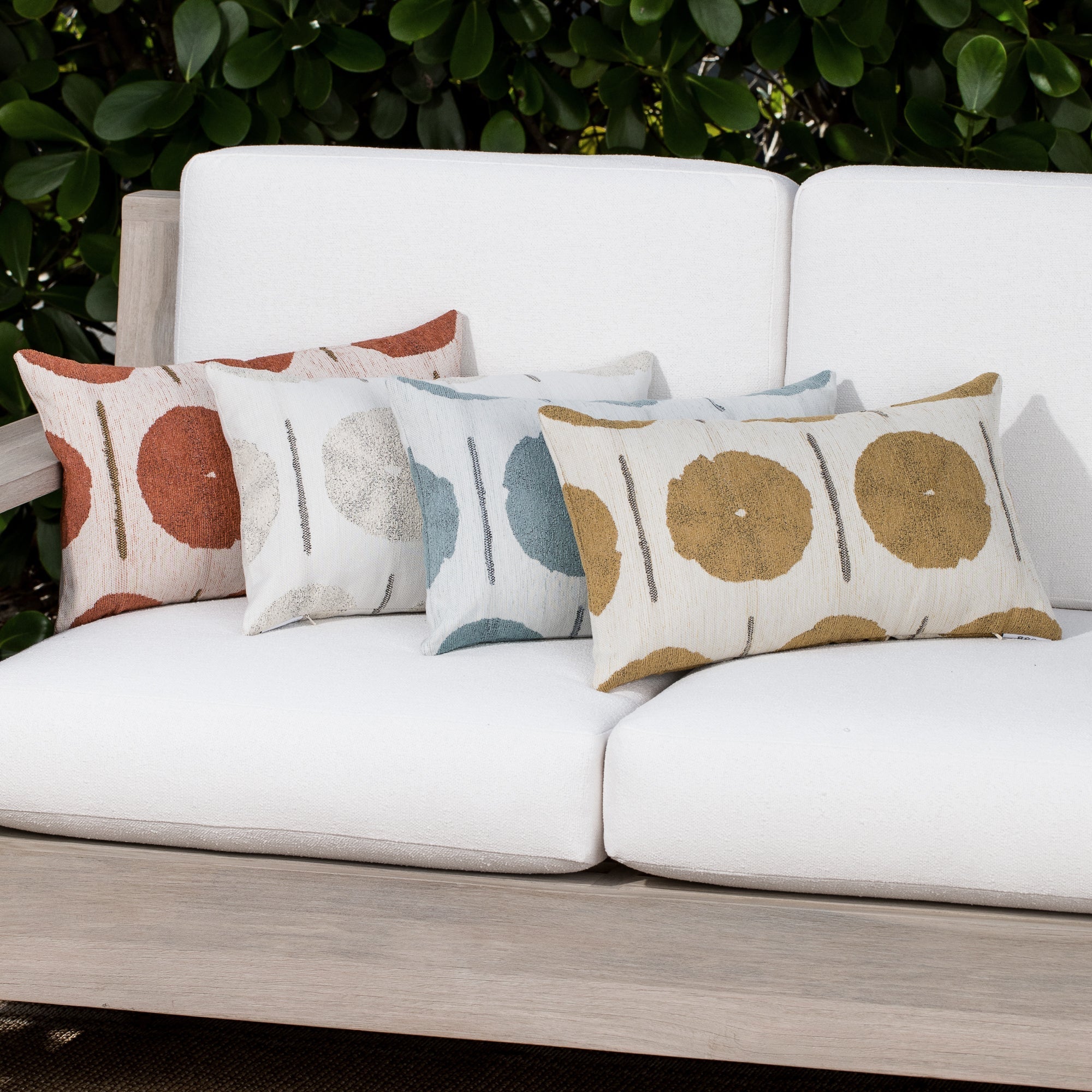 Luxury rust and cream geometric patterned accent pillow on a outdoor sofa, featuring commercial grade construction for luxury hotel and resort design