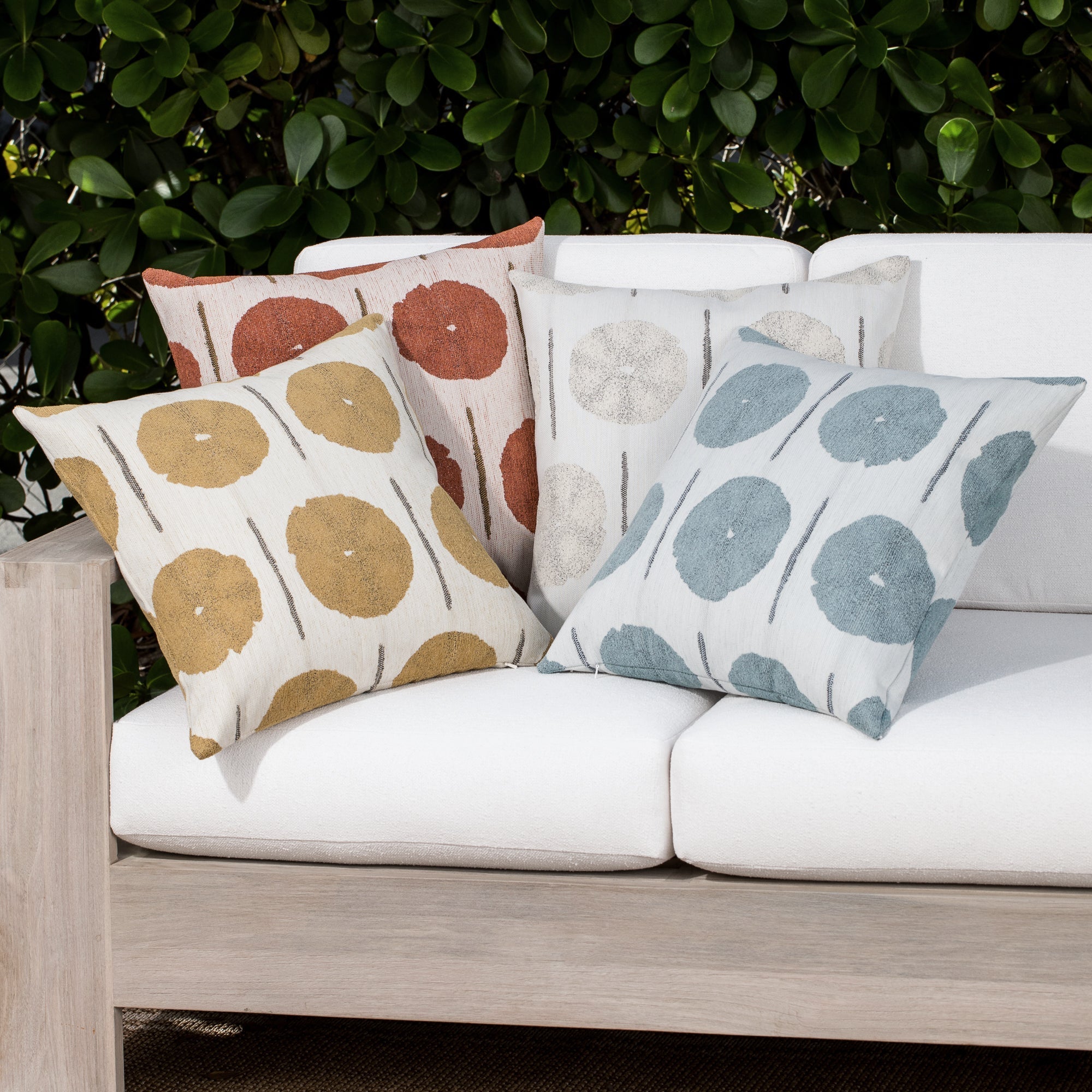 Luxury geometric patterned accent pillows in multiple colors on a outdoor sofa, featuring commercial grade construction for luxury hotel and resort design