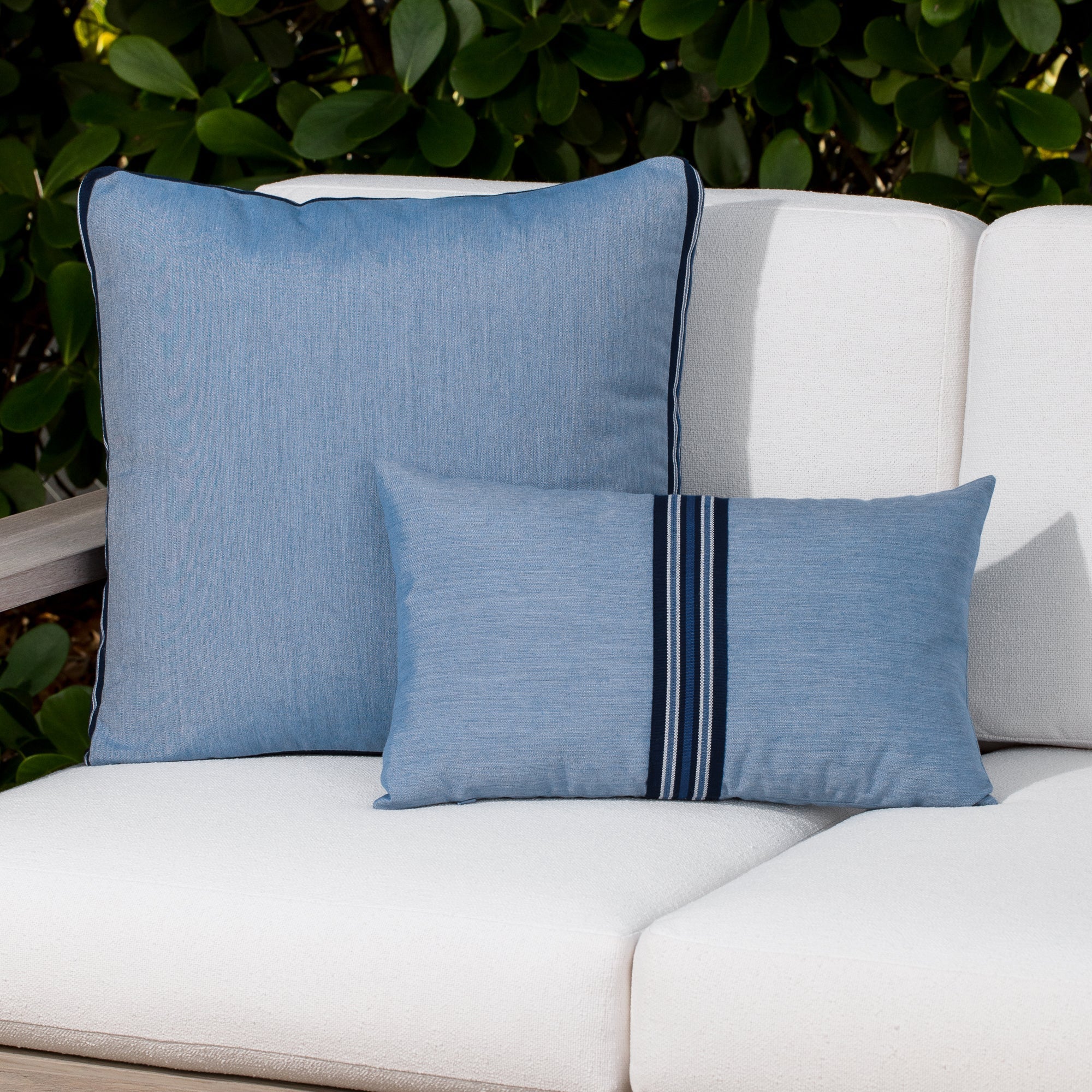 Luxury ocean blue solid accent cushion on a outdoor sofa, featuring soft touch performance weave for residential and commercial interiors