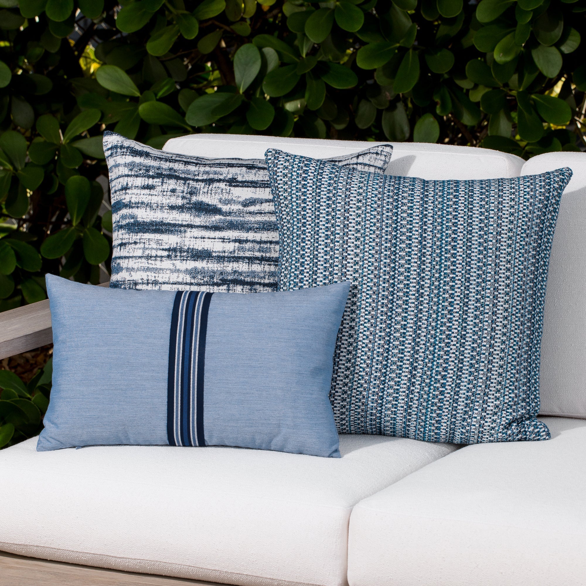 Luxury ocean blue solid accent cushion on a outdoor sofa, featuring soft touch performance weave for residential and commercial interiors