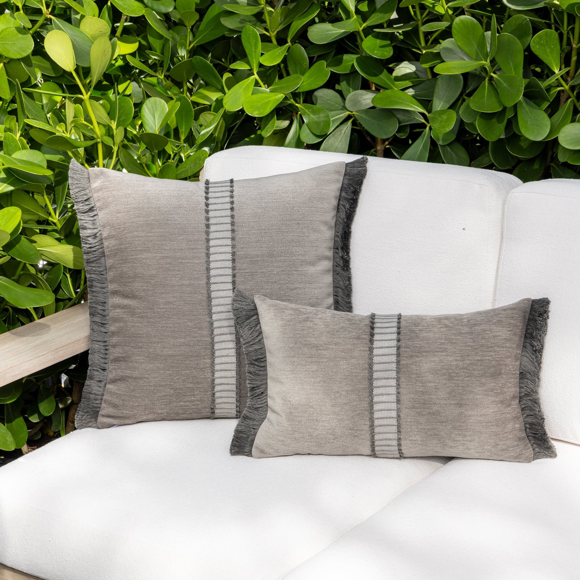 Luxury pewter velvet textured woven decorative pillows on a woven outdoor sofa, featuring solution dyed performance fibers for hospitality and commercial spaces