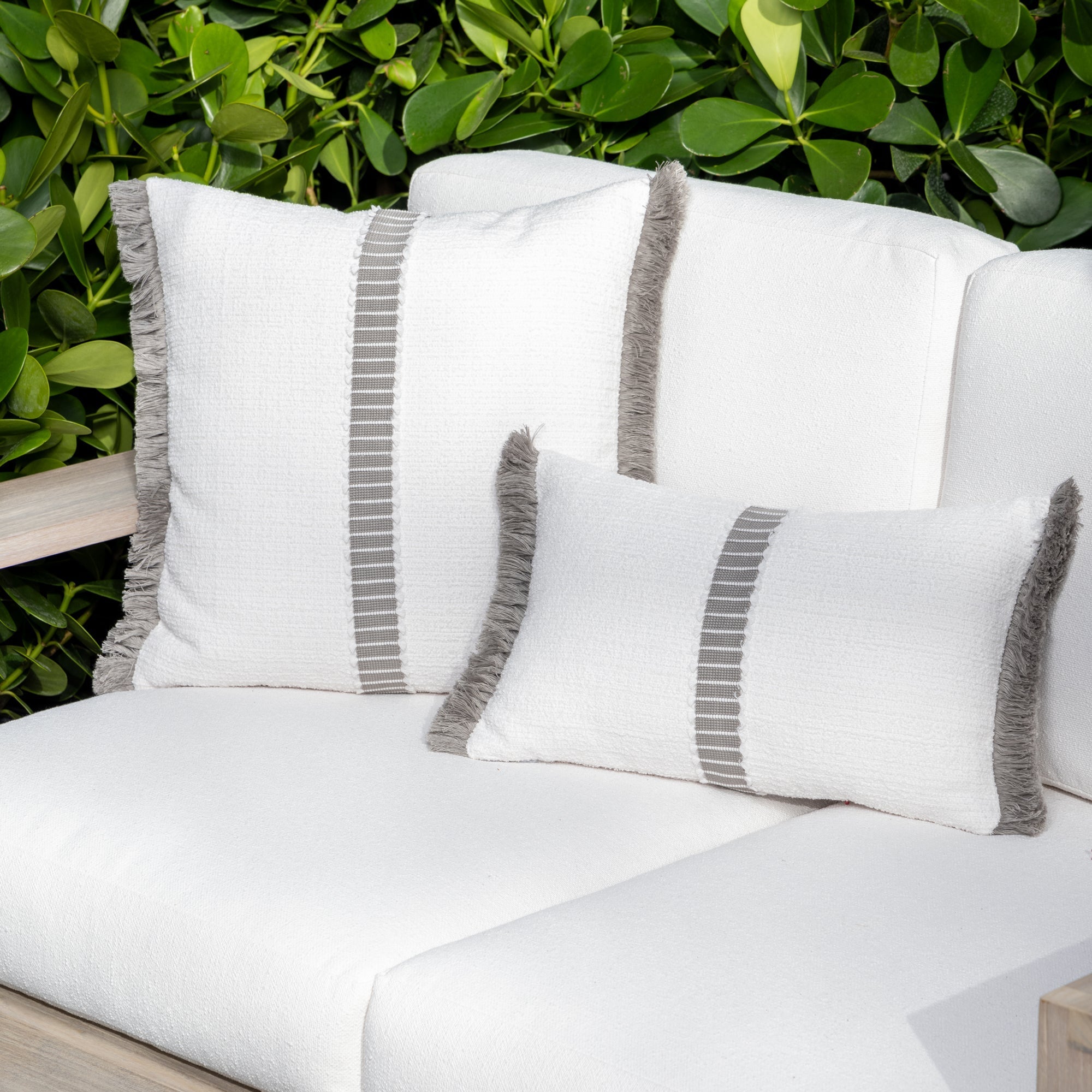 Luxury white textured woven decorative pillows on a woven outdoor sofa, featuring solution dyed performance fibers for hospitality and commercial spaces