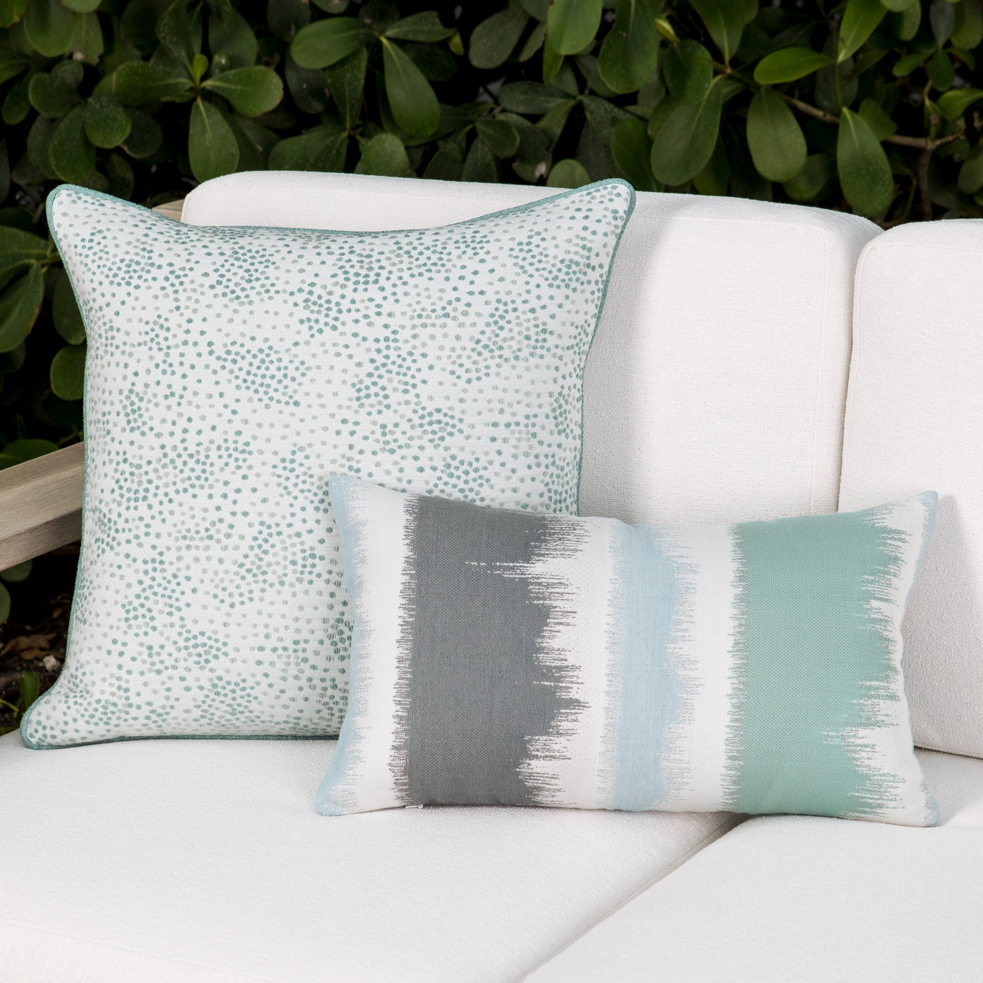 Luxury blue and green and ivory subtle patterned bolster pillow on a resort cabana dayoutdoor sofa, featuring plush fill for lasting comfort for hospitality and commercial spaces