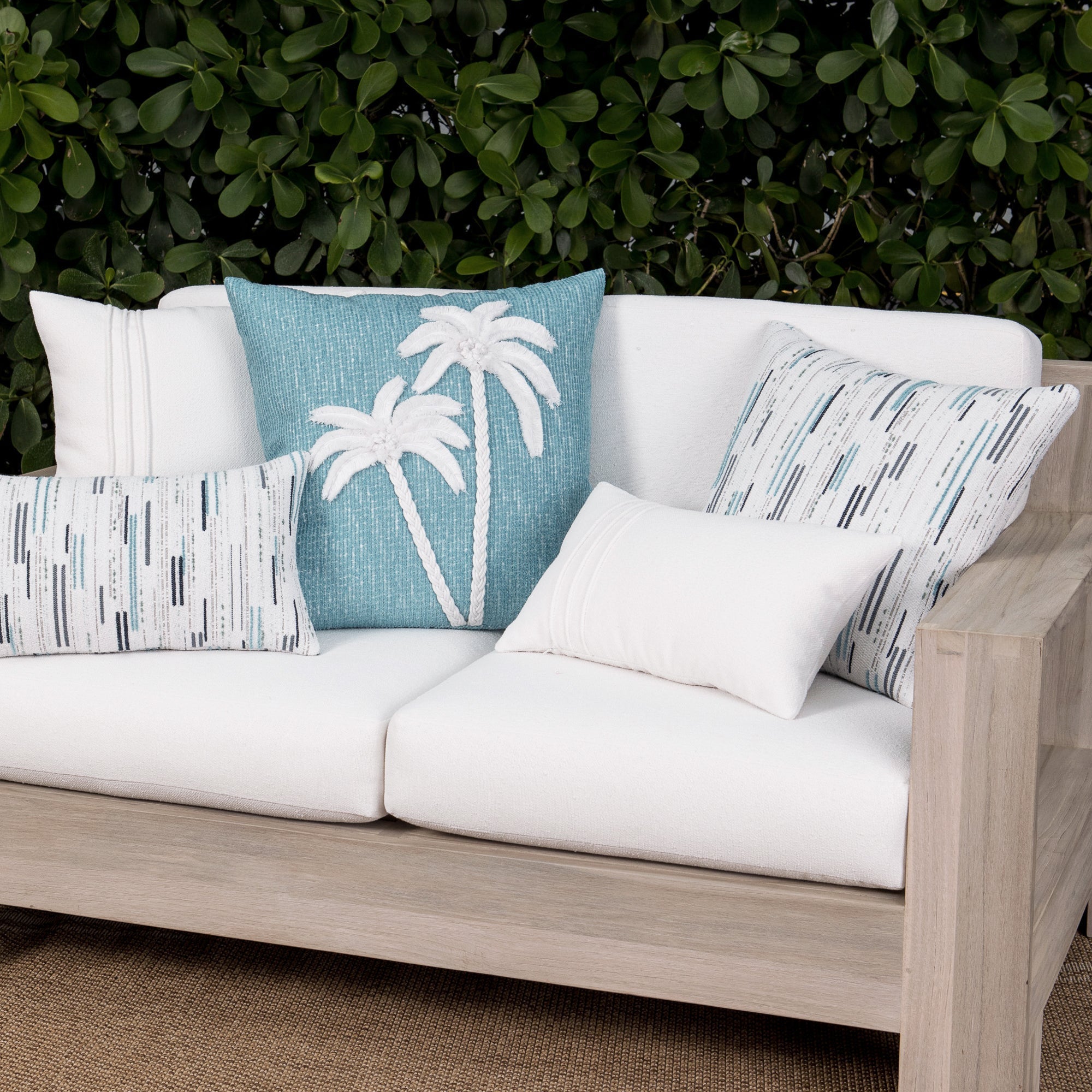 Luxury white textured and ocean floral accent cushions on a outdoor sofa, featuring UV and fade resistant fabric to complete indoor and outdoor decor