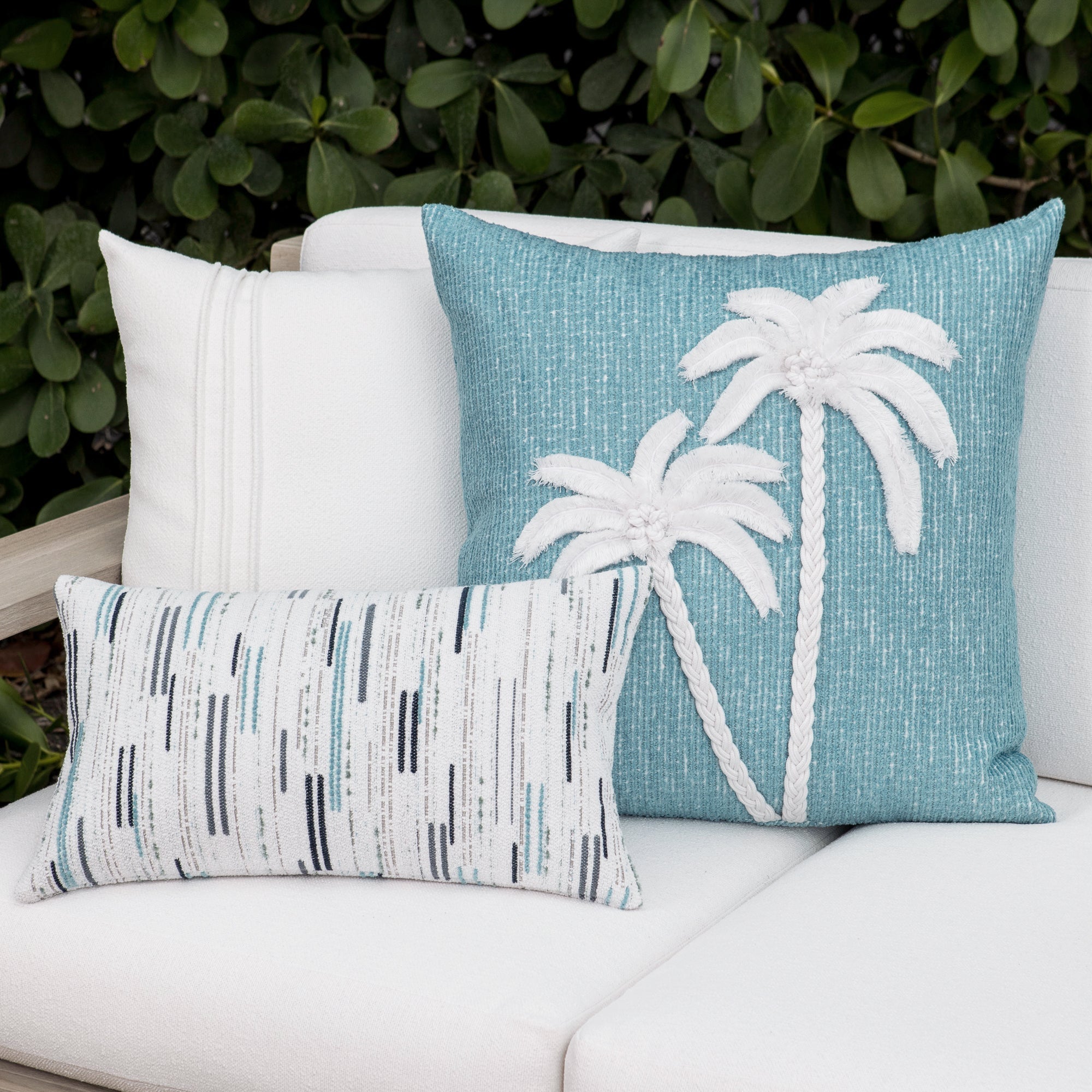 Luxury white textured and ocean floral accent cushions on a outdoor sofa, featuring UV and fade resistant fabric to complete indoor and outdoor decor