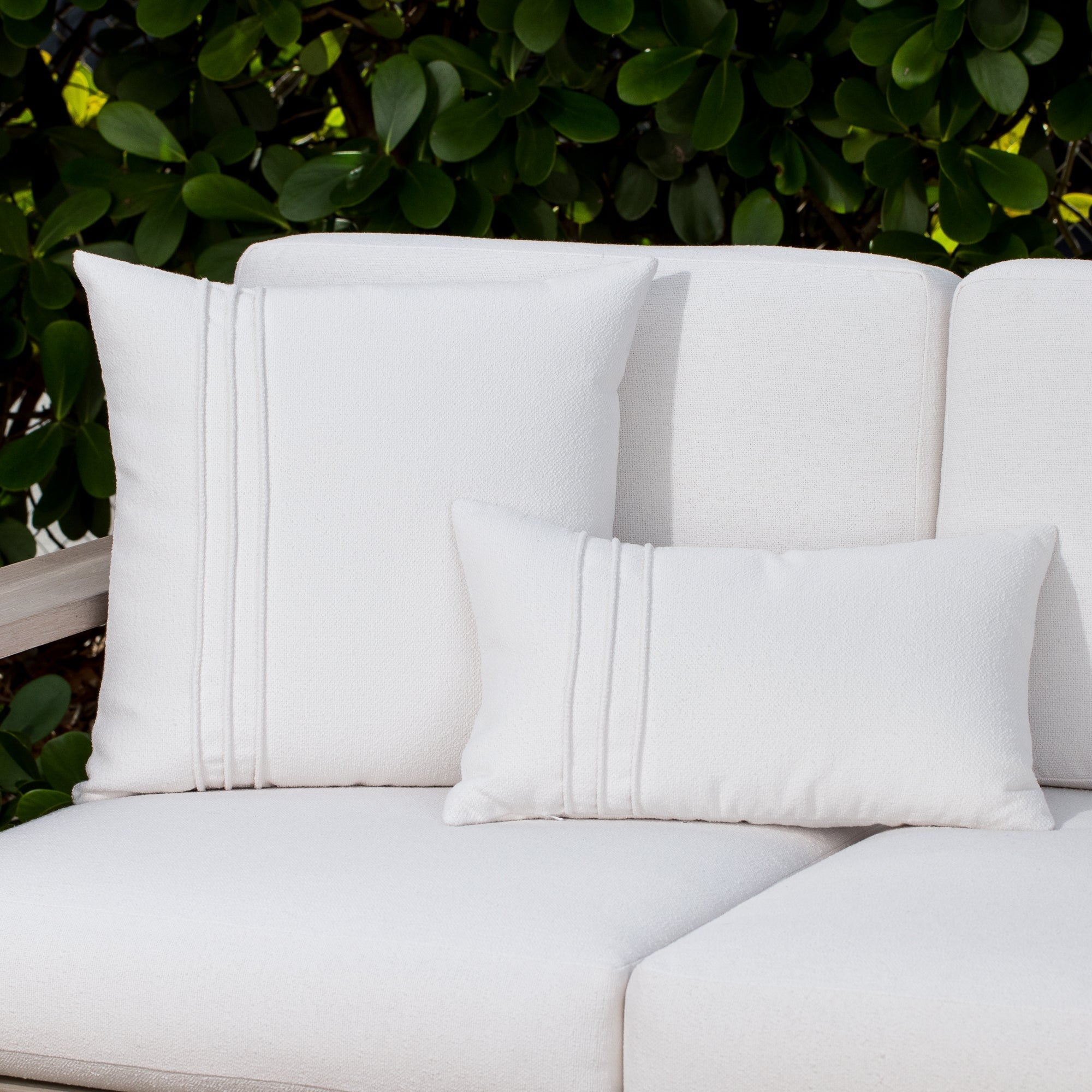 Luxury white textured and ocean floral accent cushions on a outdoor sofa, featuring UV and fade resistant fabric to complete indoor and outdoor decor