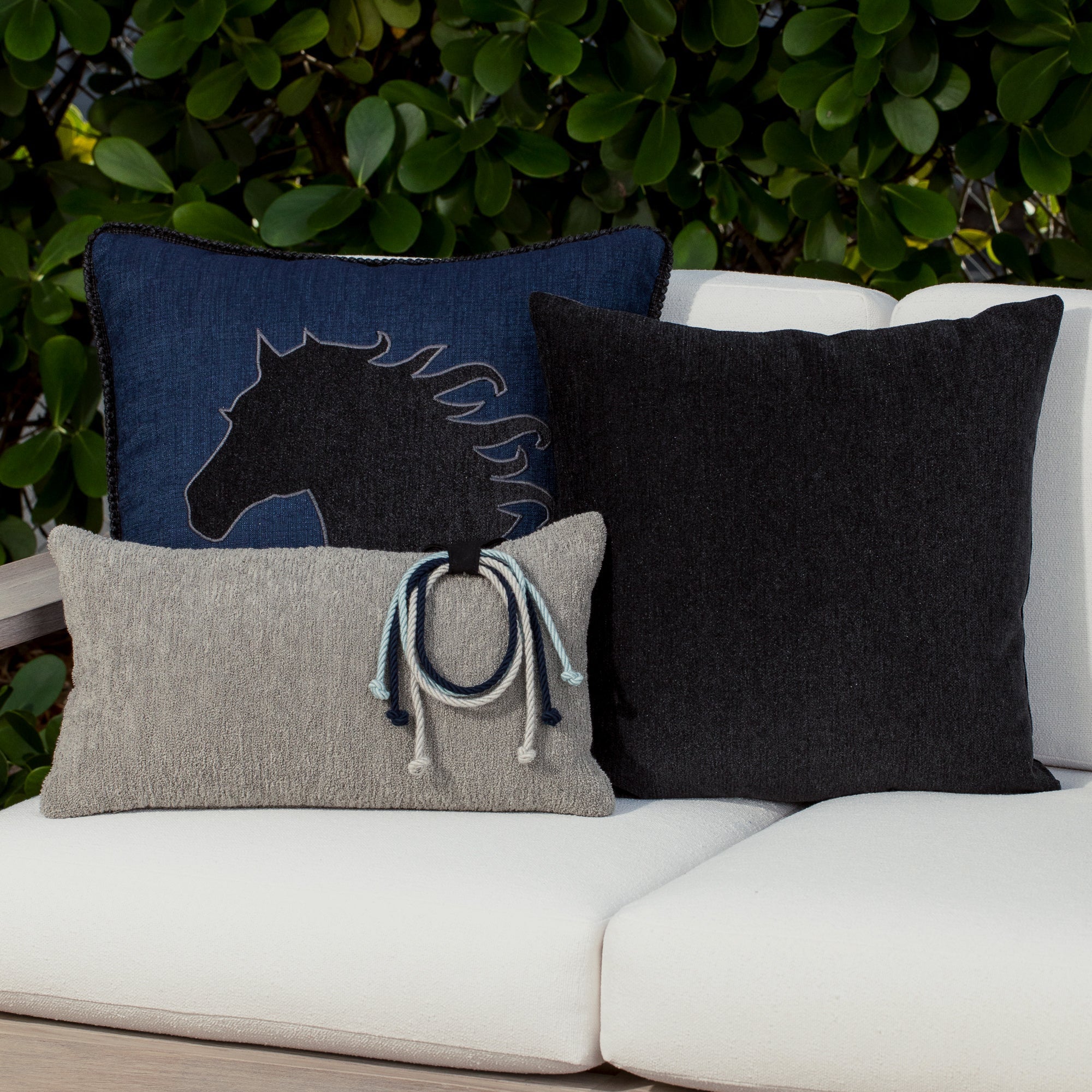 Luxury denim, and gray modern patterned pillows on a outdoor sofa, featuring solution dyed performance fibers for hospitality and commercial spaces