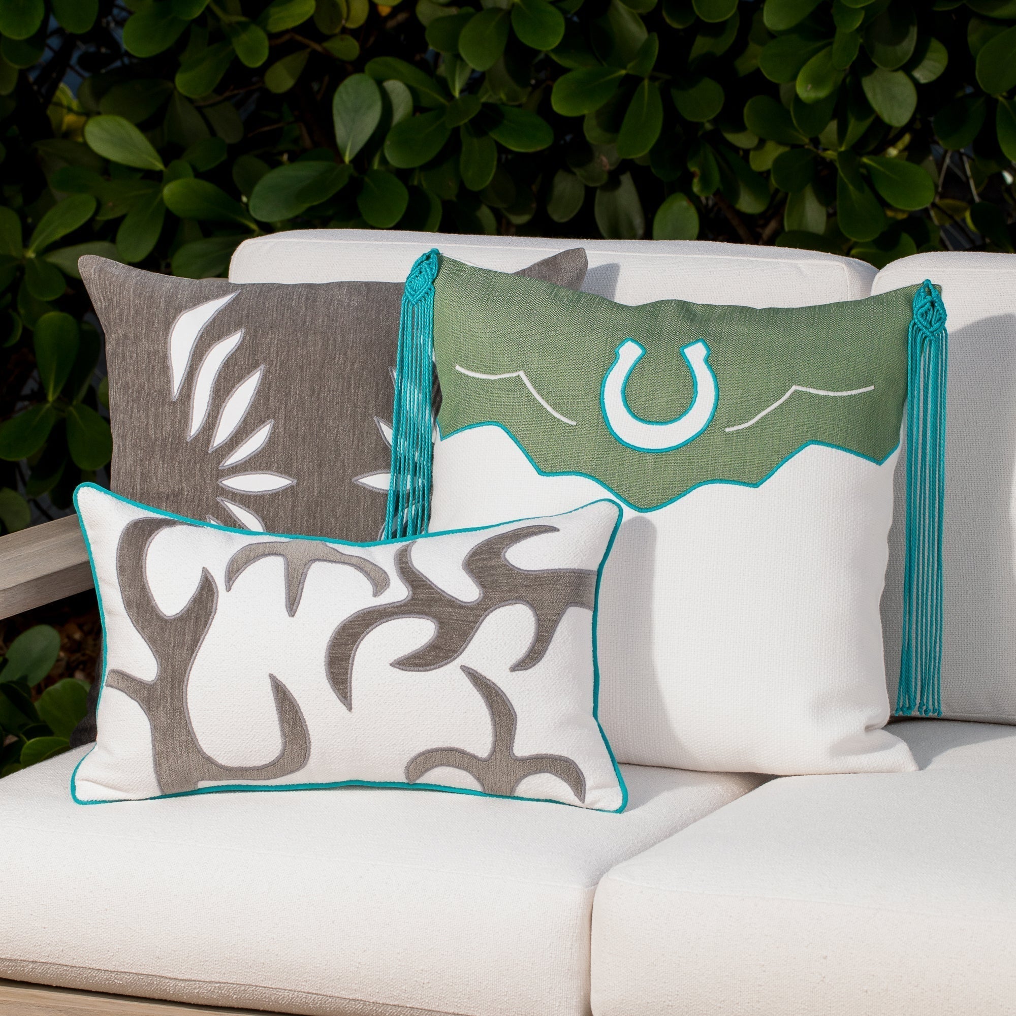 Luxury green, white and gray western patterned pillows on a outdoor sofa styled for hospitality suites, featuring easy clean performance fabric for luxury hotel and resort design by Elaine Smith