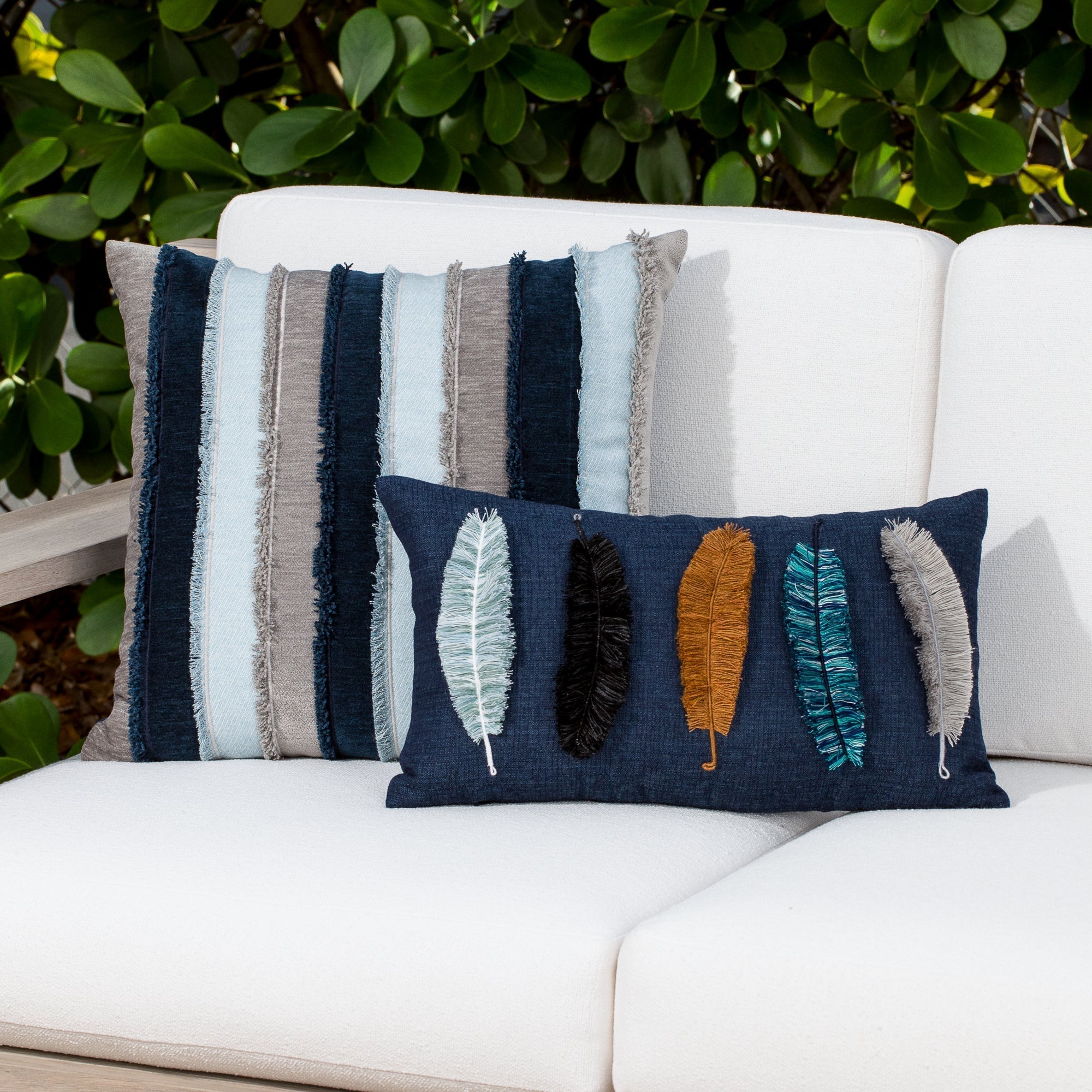 Luxury striped, denim and feather handstitched woven cushion on an outdoor sofa, featuring commercial grade construction for luxury hotel and resort design
