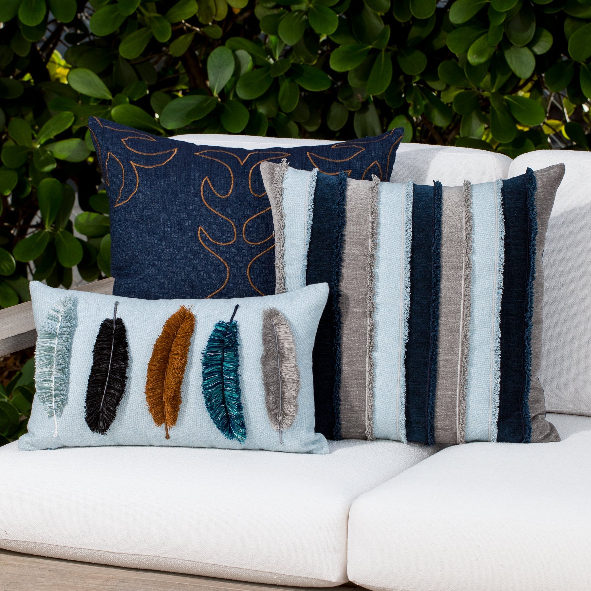 Luxury striped, light blue and feather handstitched woven cushion on an outdoor sofa, featuring commercial grade construction for luxury hotel and resort design