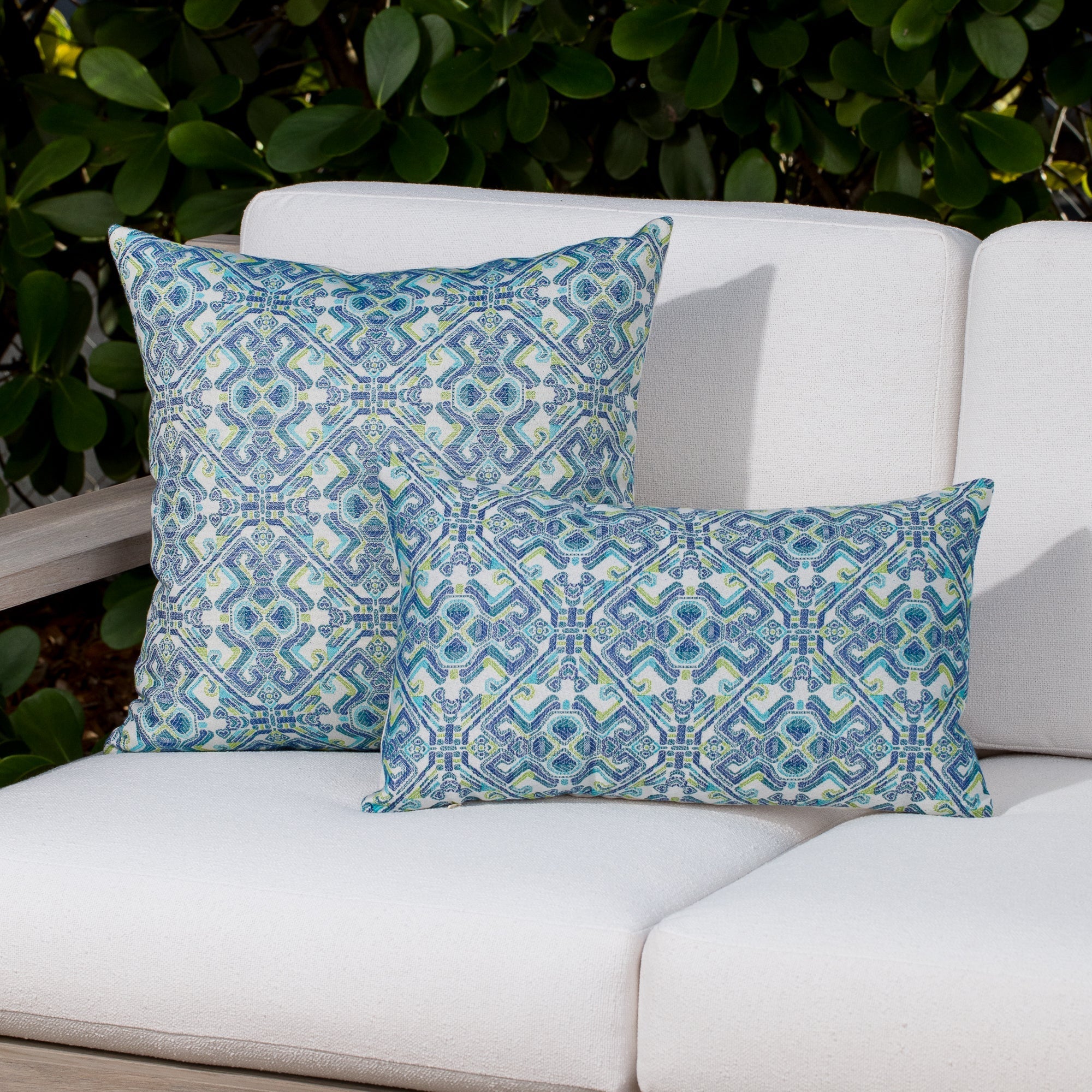 Luxury small scale pattern in green and blue accent pillow on an outdoor sofa, featuring soft touch performance weave for residential and commercial interiors