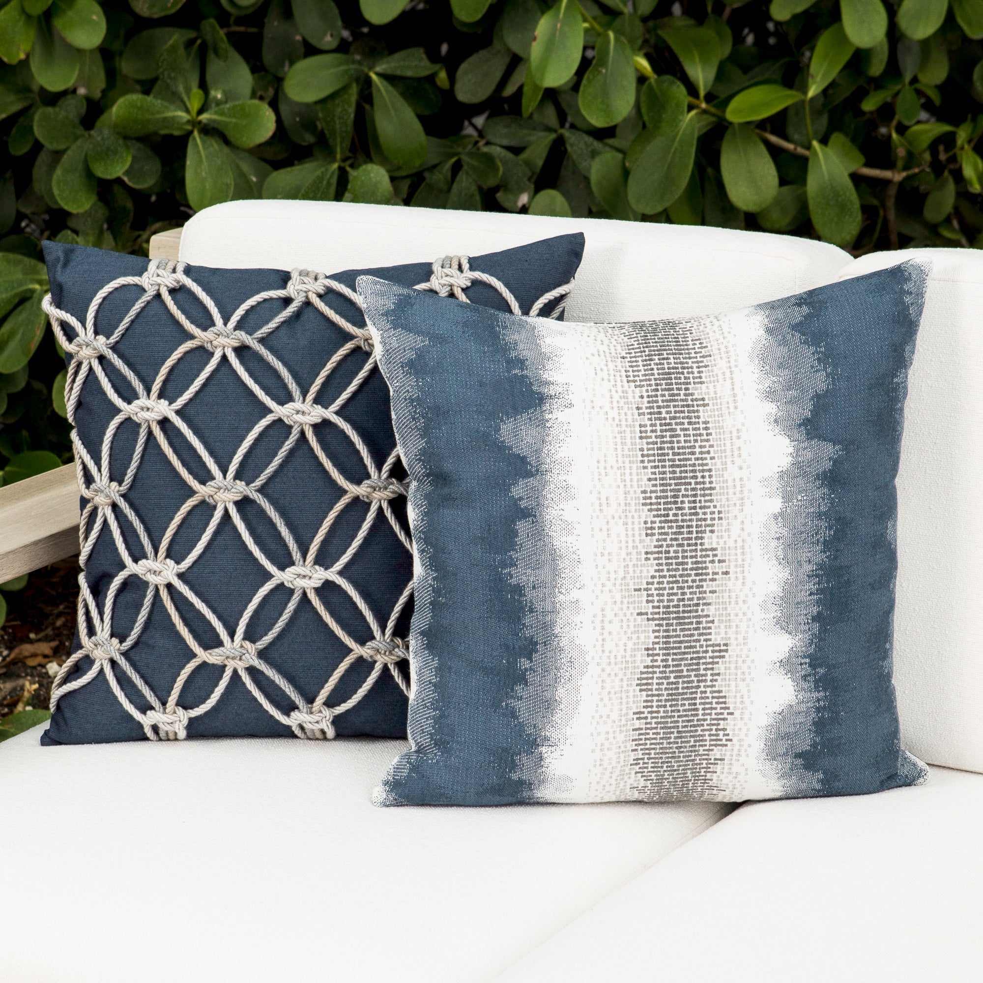 Outdoor image of denim blue pillows with hand appliqued rope detailing in multi colors for indoor and outdoor use.