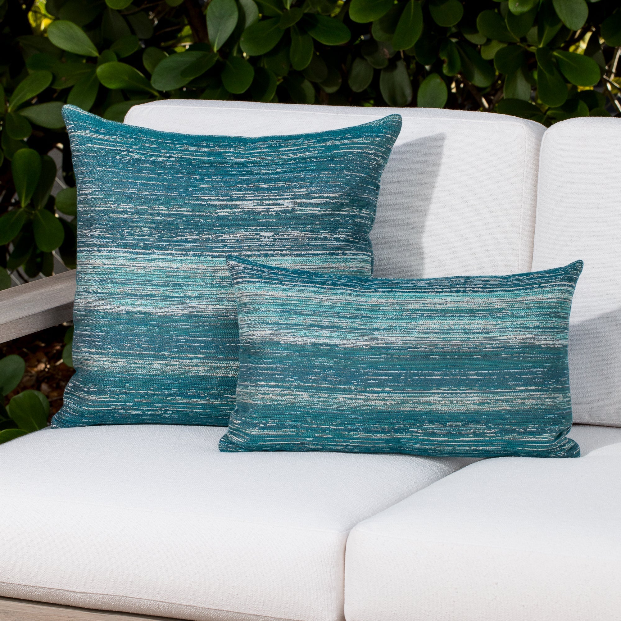 Outdoor image of pillows in Lagoon-toned outdoor-safe fabric with textured vertical streaks