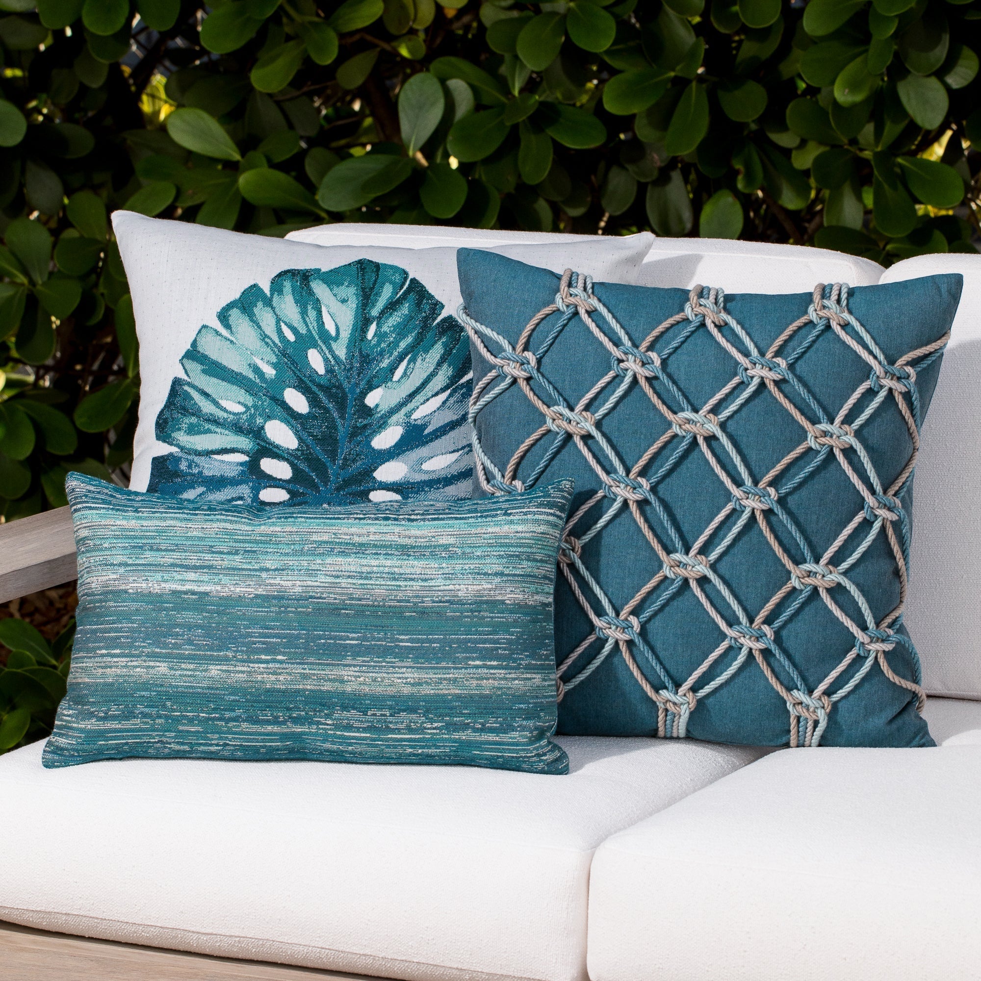 Outdoor image of teal ombre stripe pillows on outdoor sofa