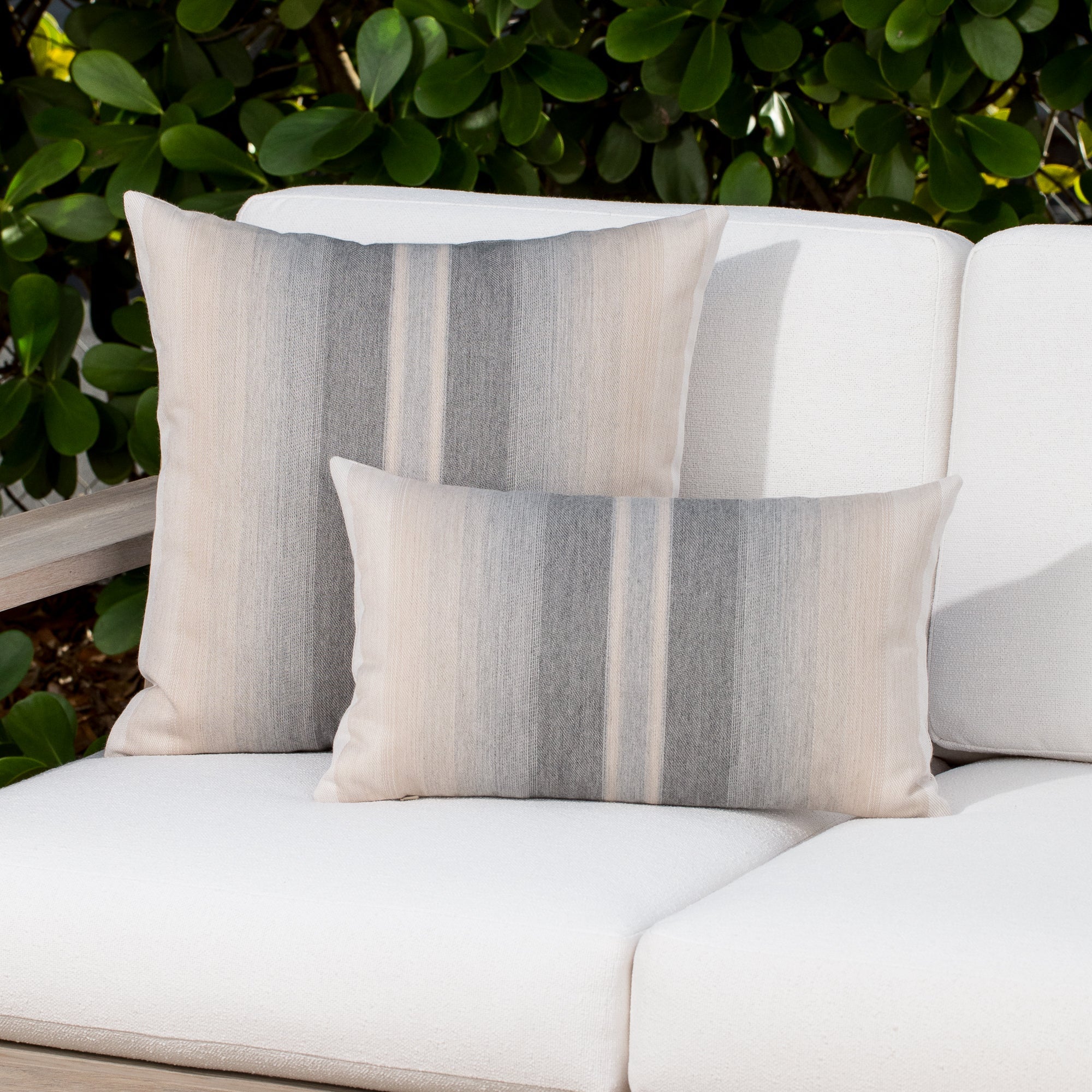 Luxury gray striped patterned accent cushion on an outdoor sofa, featuring soft touch performance weave for residential and commercial interiors