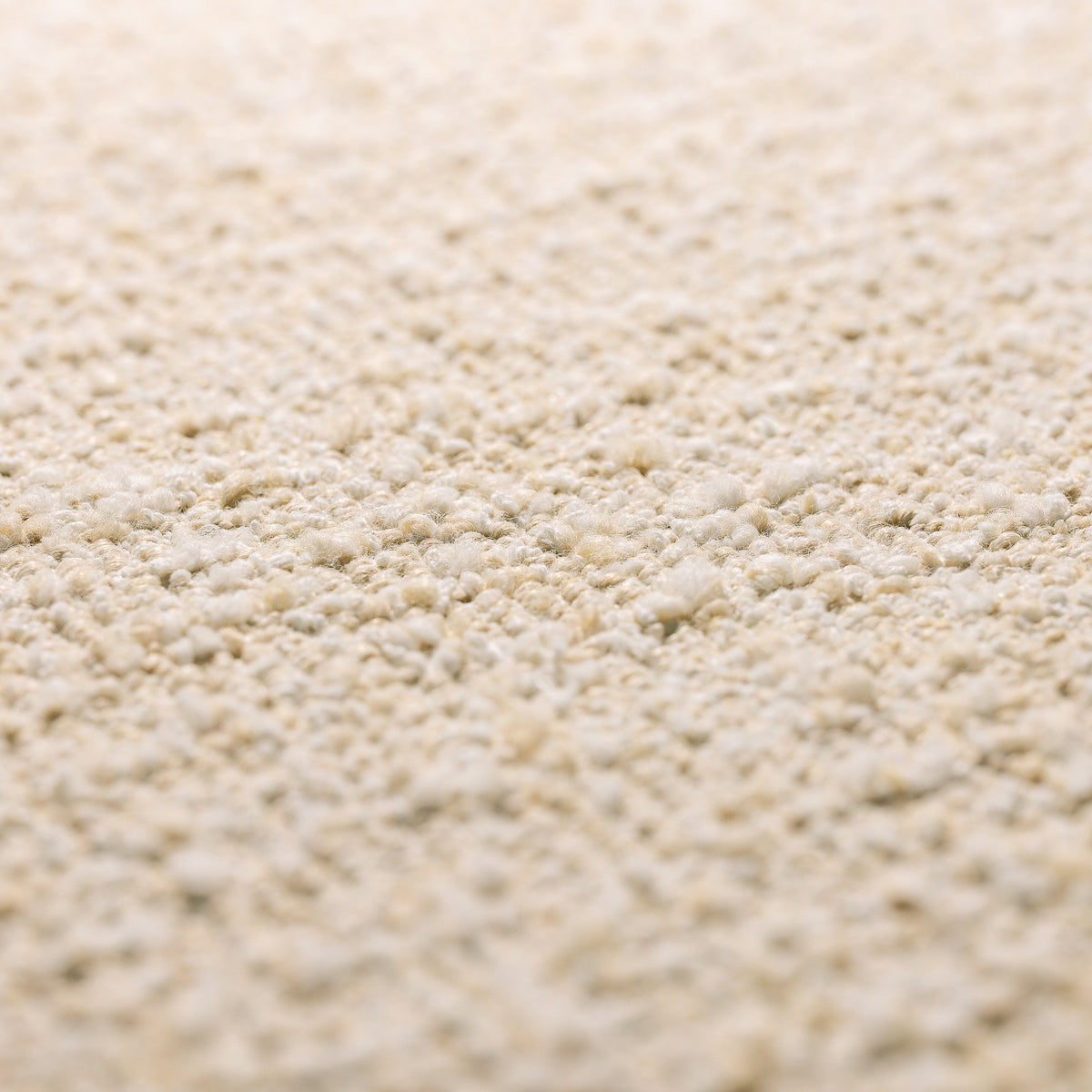 A close-up texture shot of a light beige, granular material such as sand, gravel, or fine sandpaper.