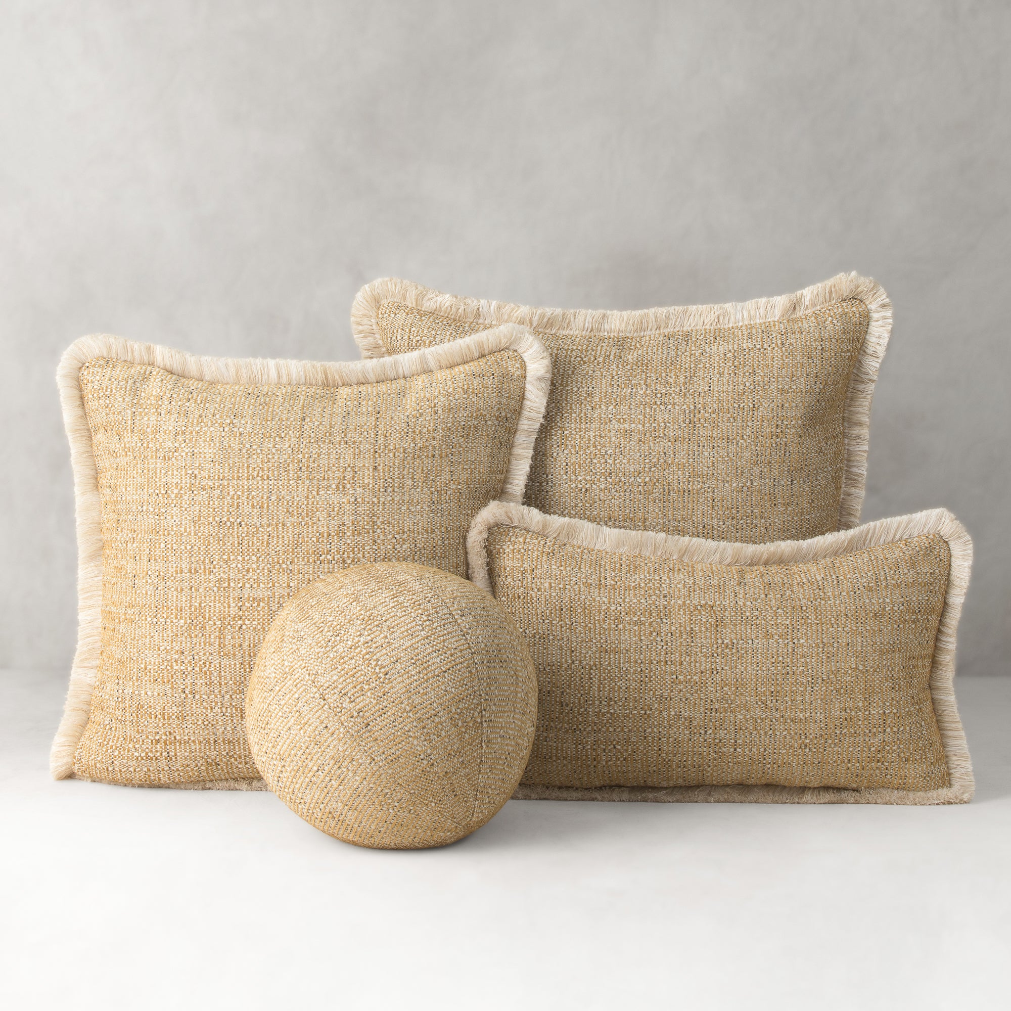Three beige textured pillows and a round ball on a light gray background- outdoor safe by Elaine Smith