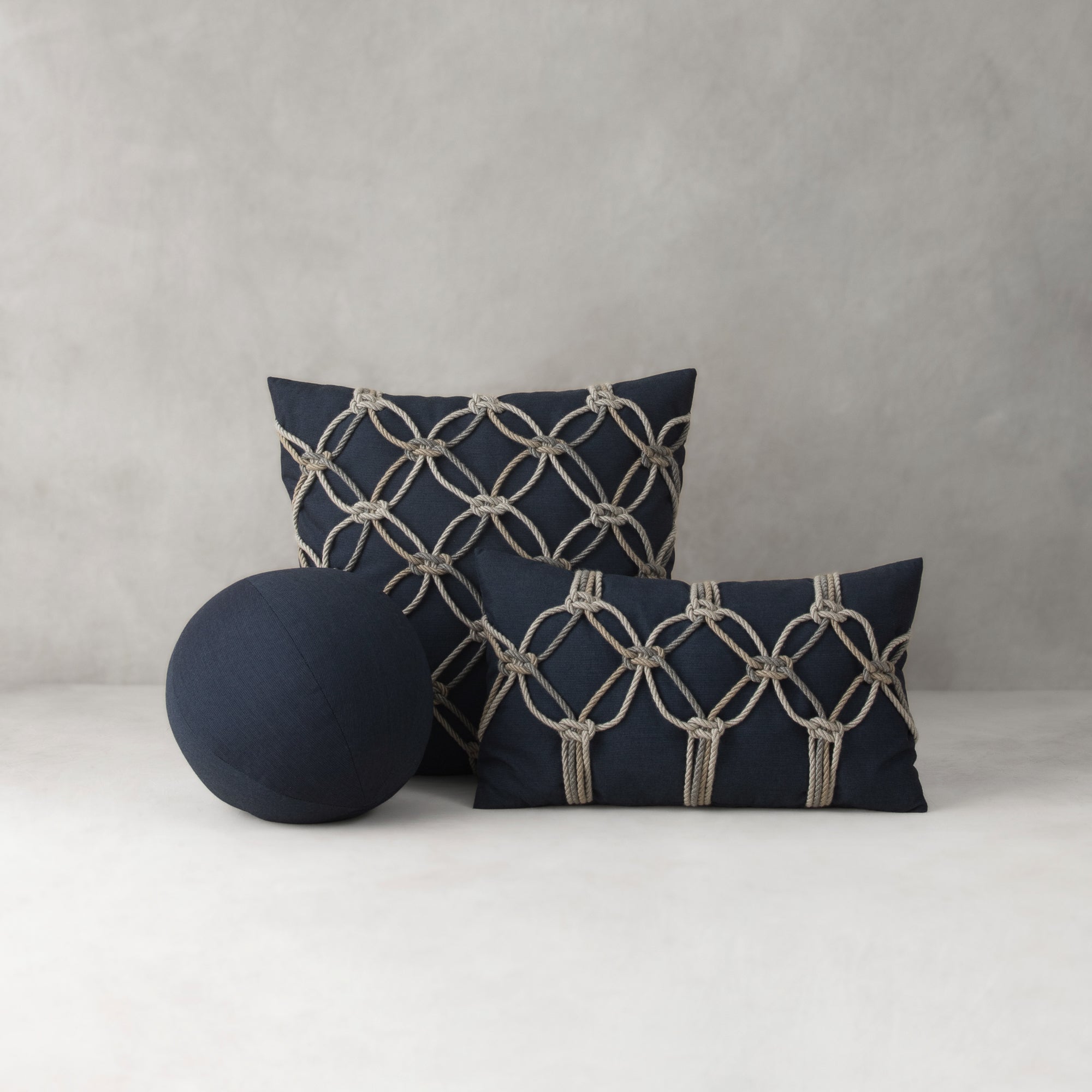 Navy blue pillows with geometric patterns on a light gray background