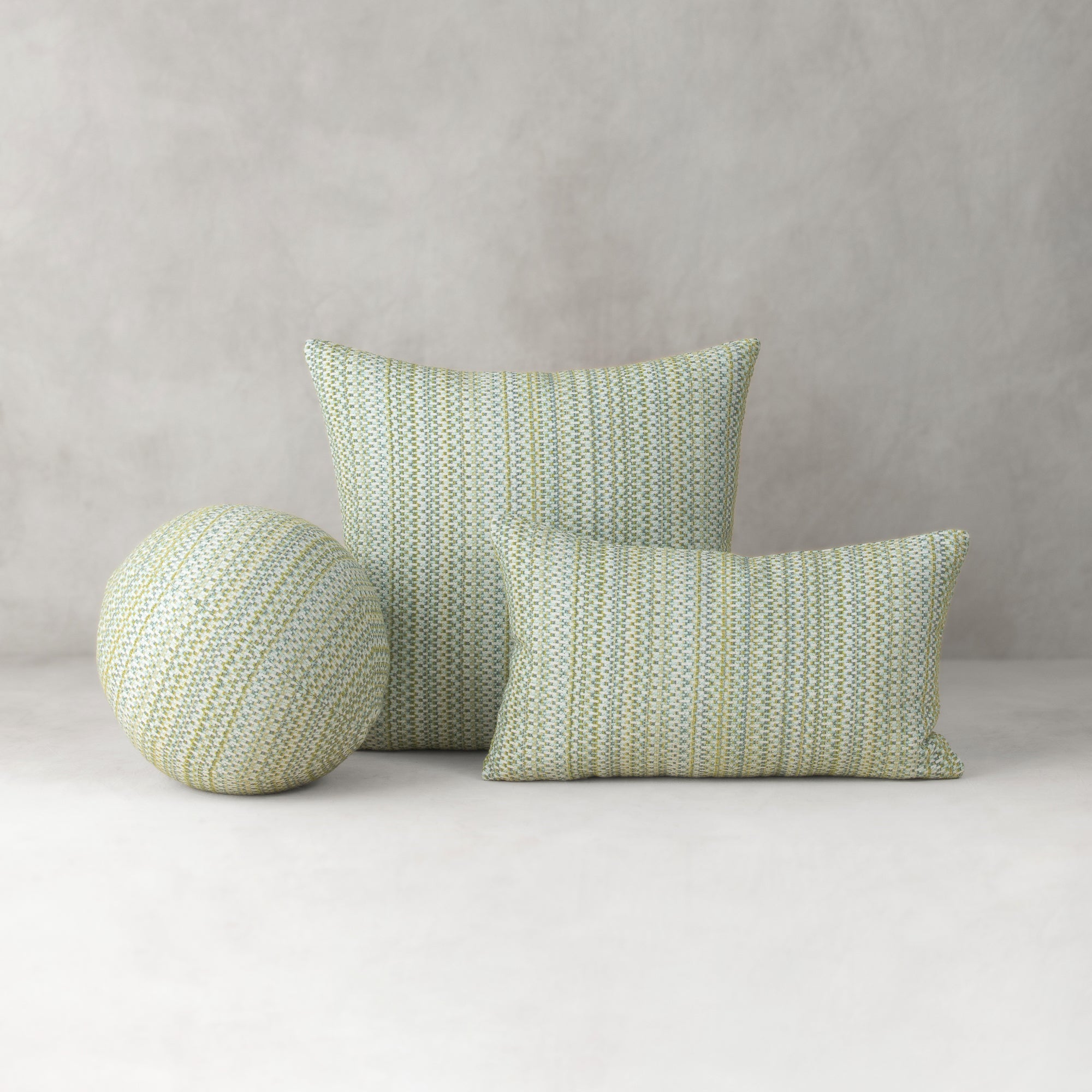 Green patterned cushions on a light gray background