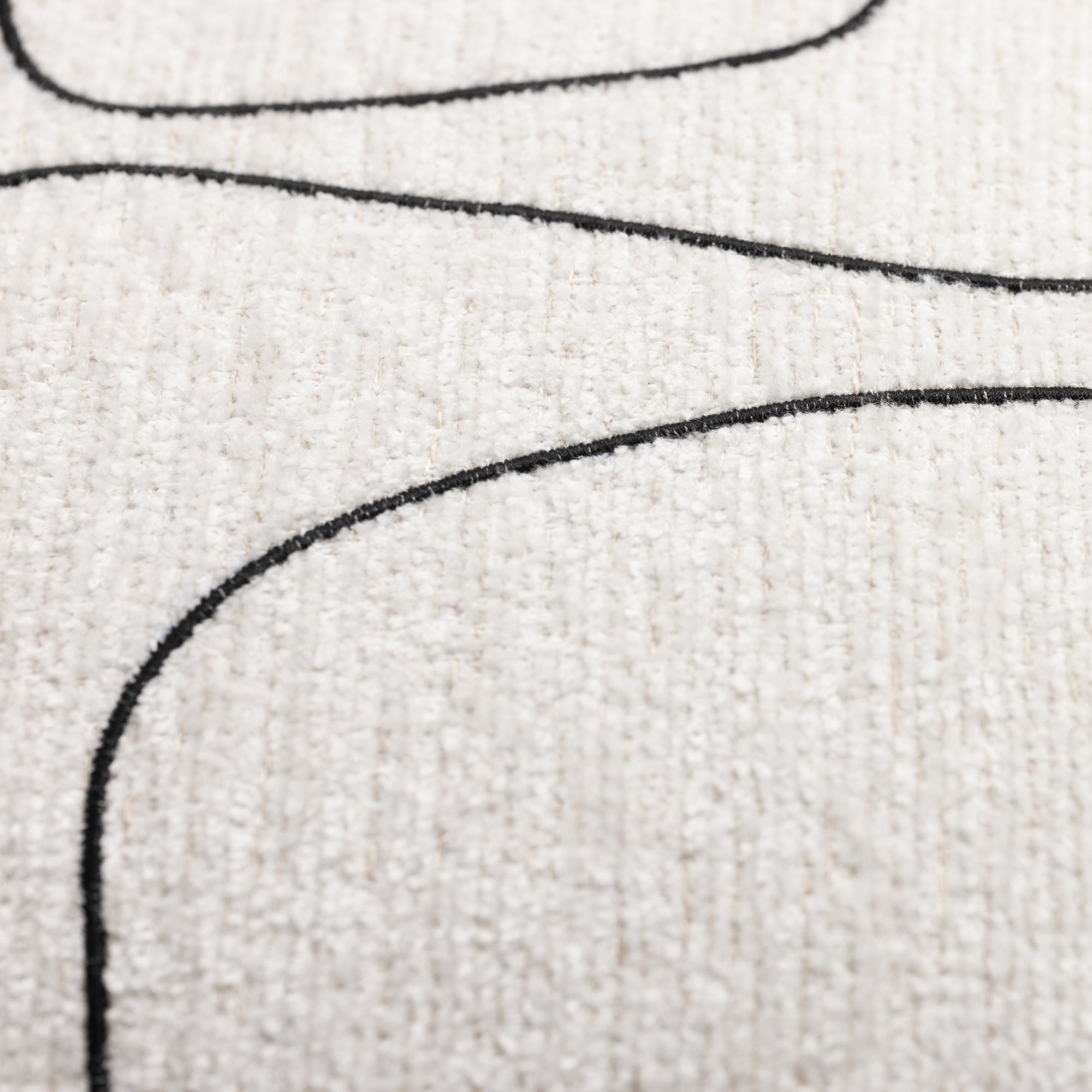 Close-up of textured fabric with black embroidered lines