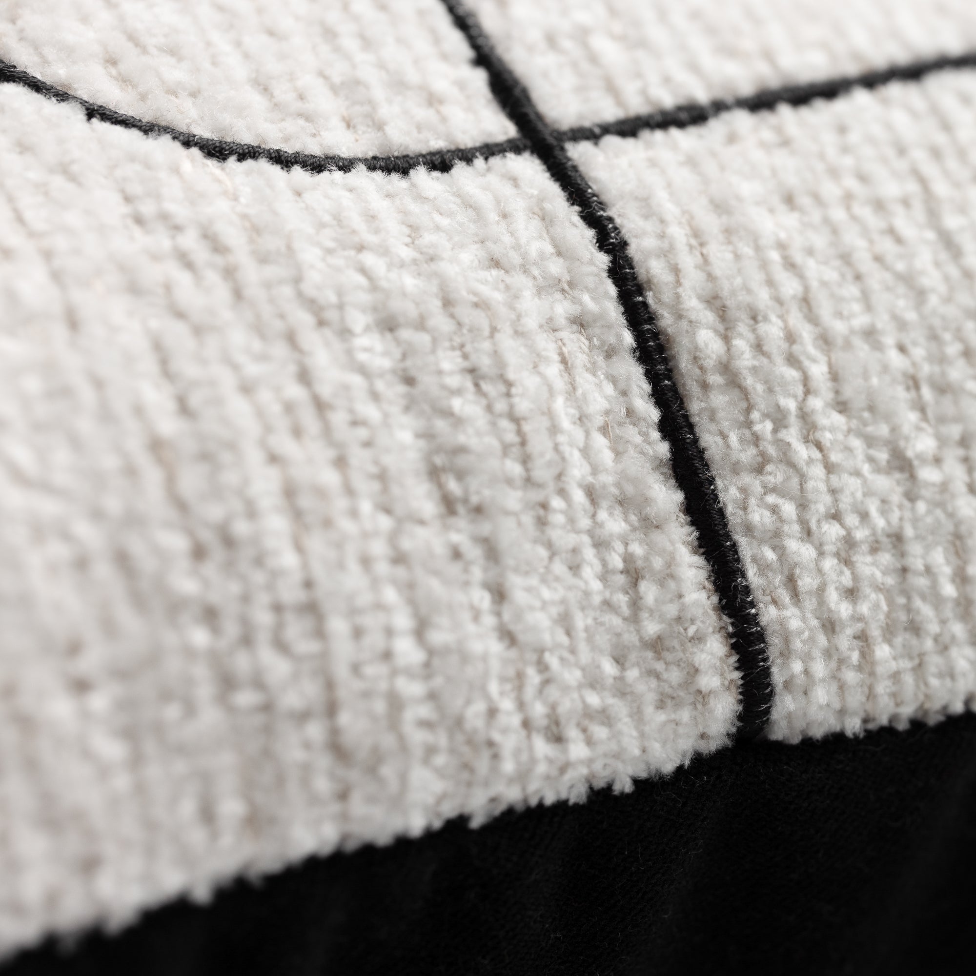 Close-up of a textured fabric with black grid lines on a white background