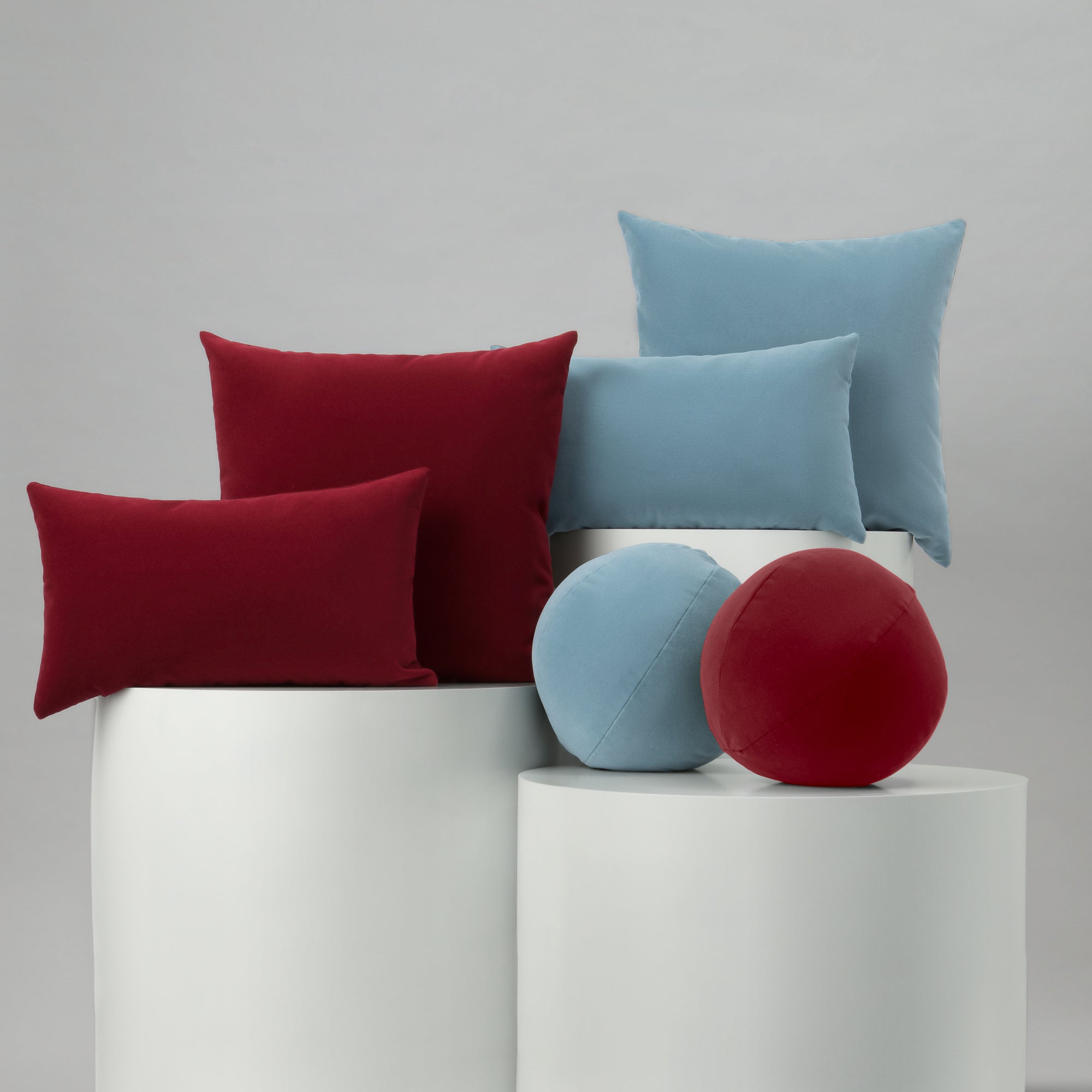 Colorful cushions and balls on a white surface with a gray background