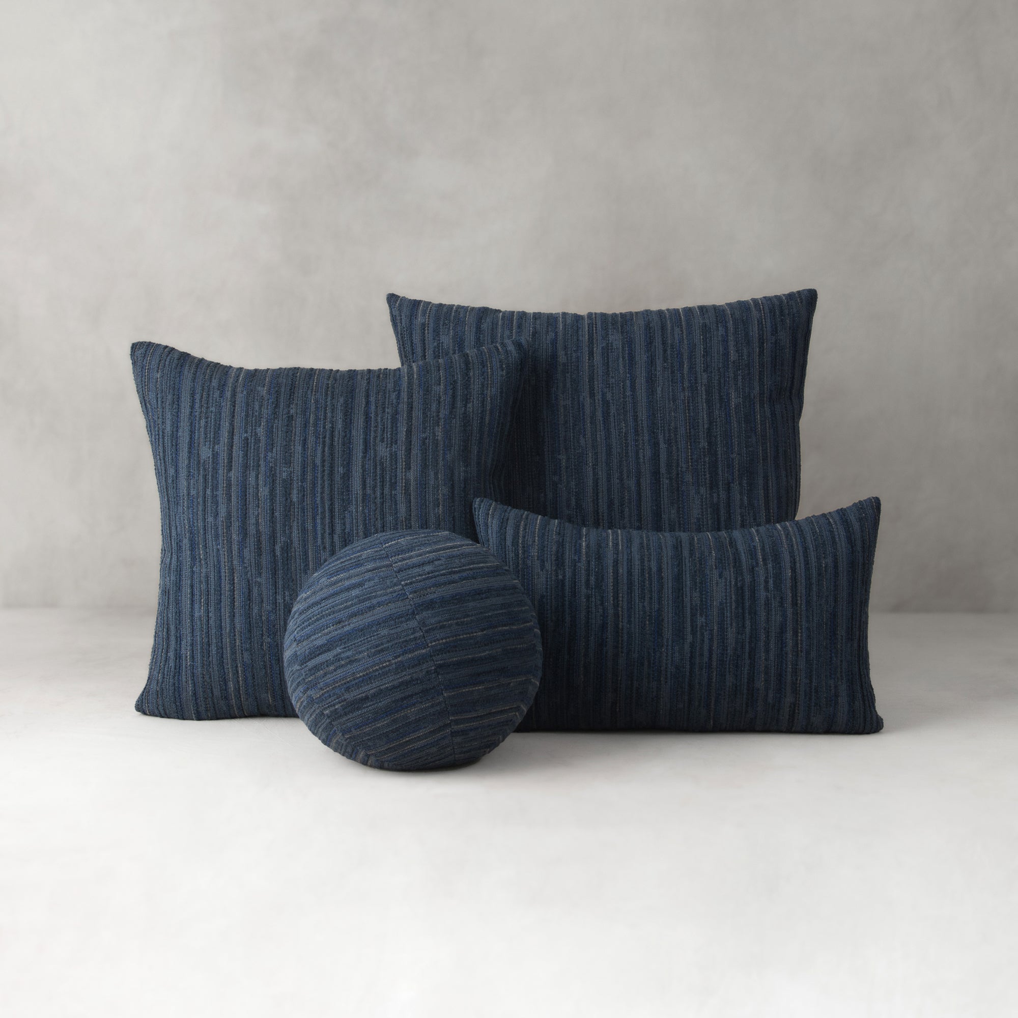 Set of blue textured cushions on a light gray background