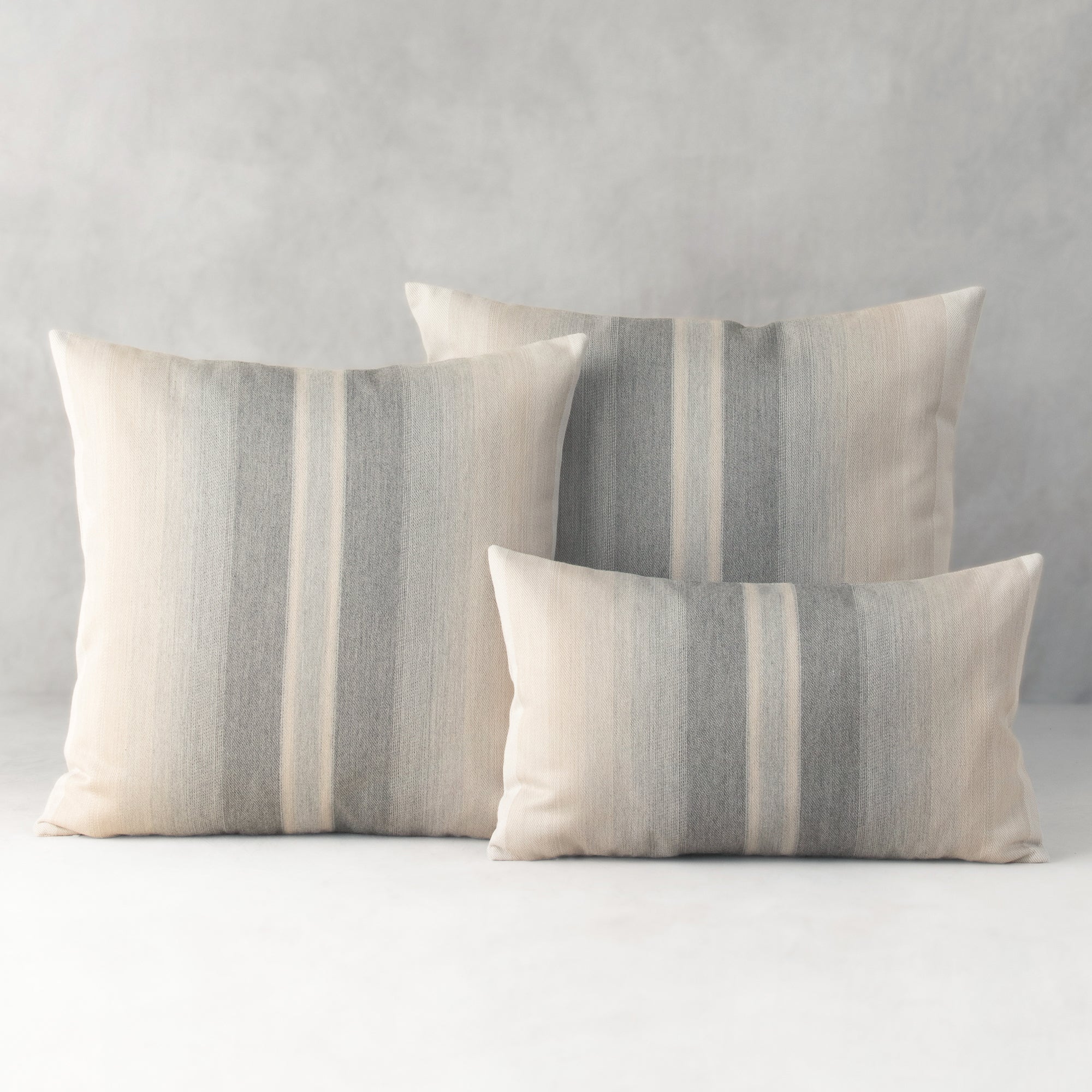 Three striped pillows on a light gray background