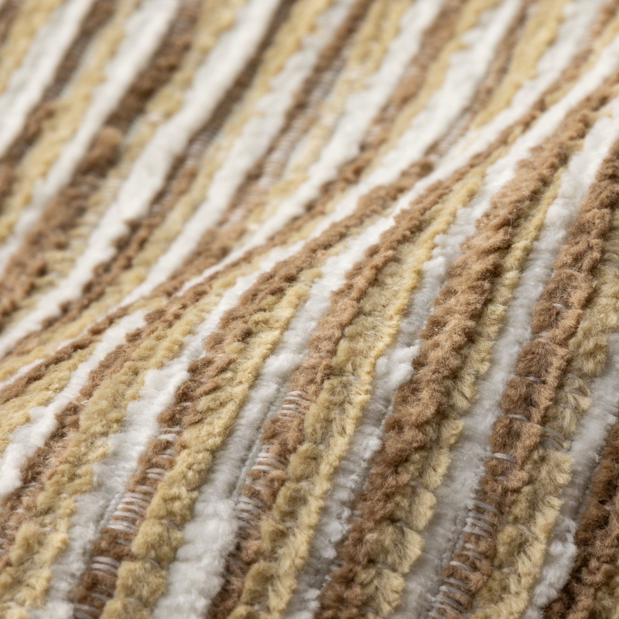 Close-up of textured carpet with brown, beige, and white stripes