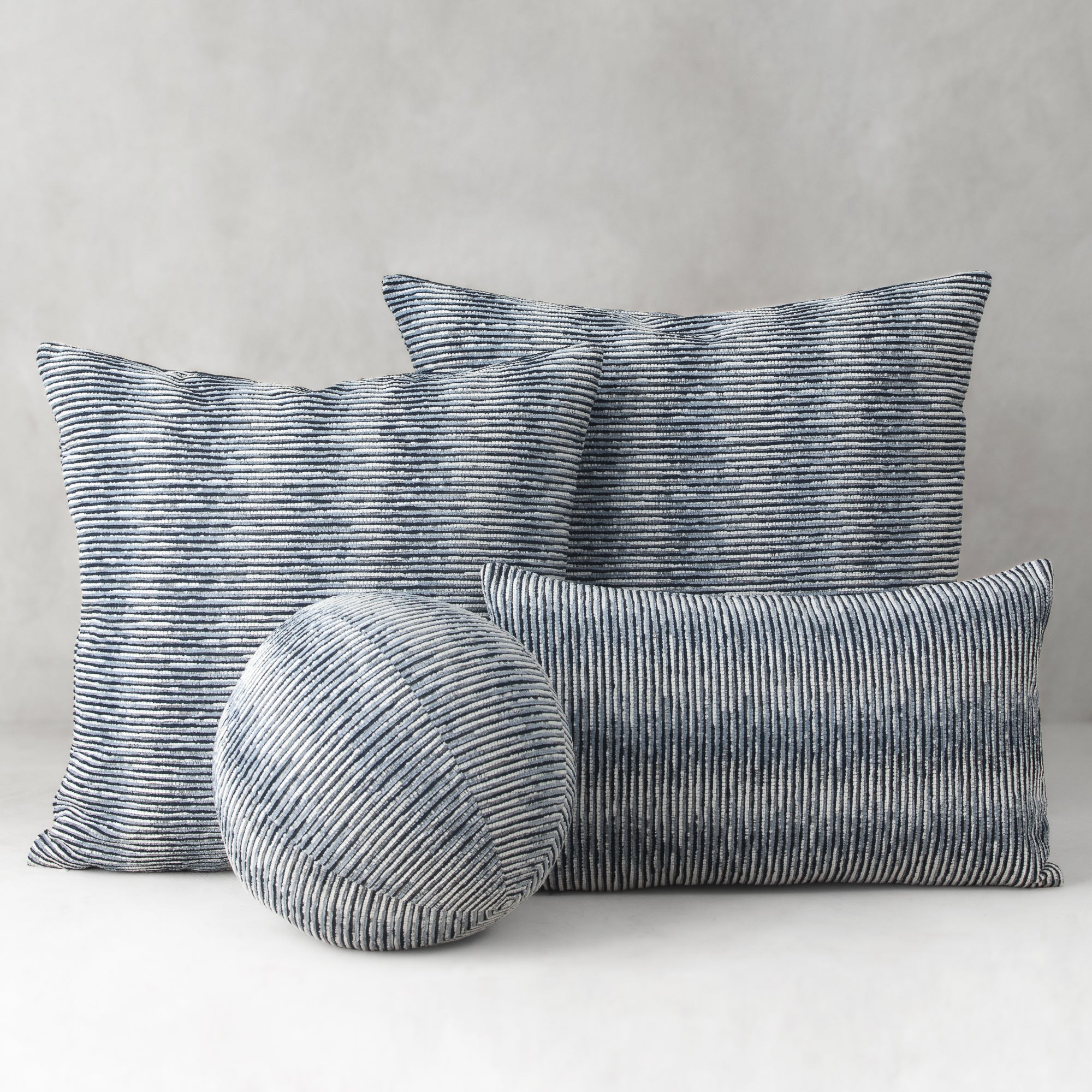Set of striped cushions on a neutral background