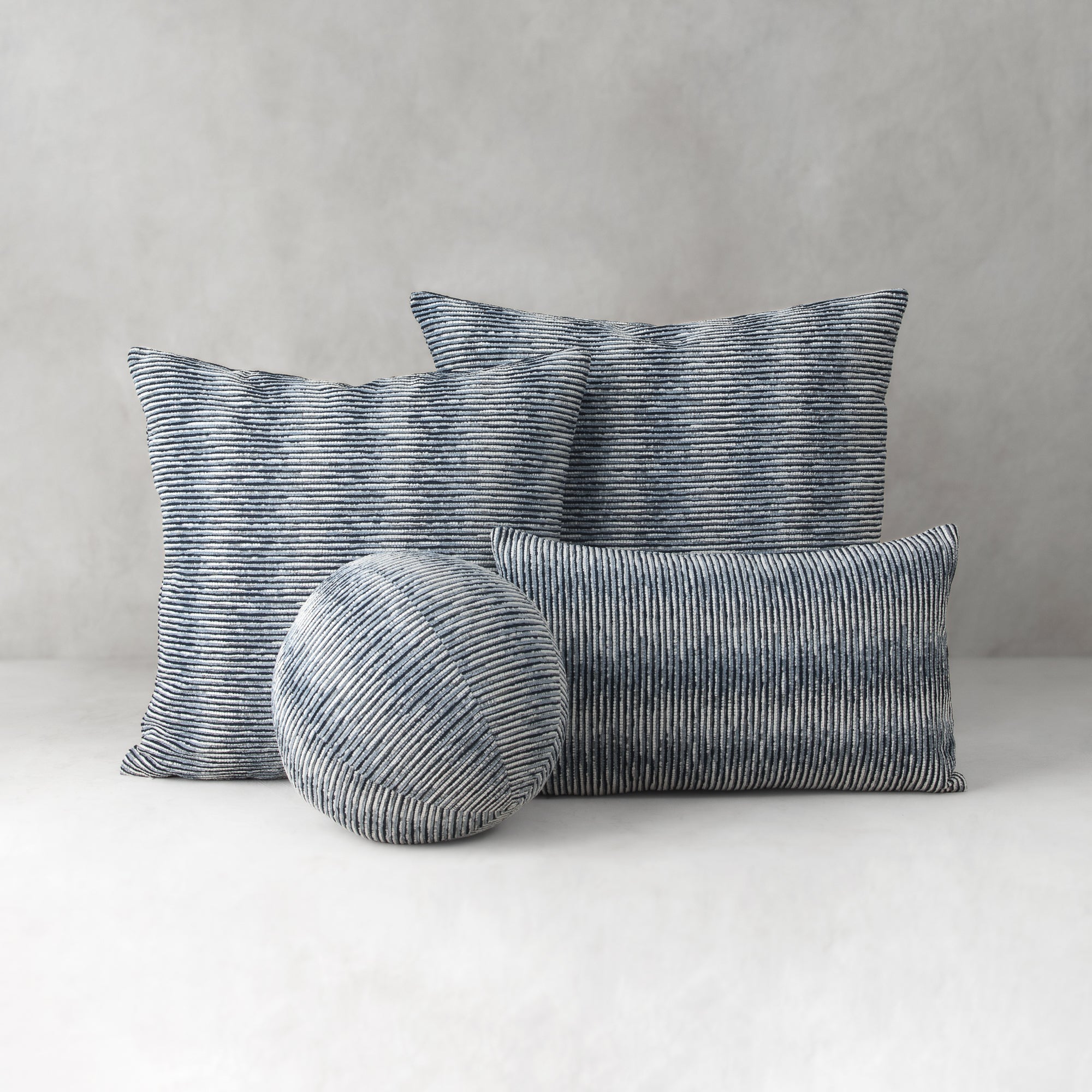 Set of striped cushions on a neutral background