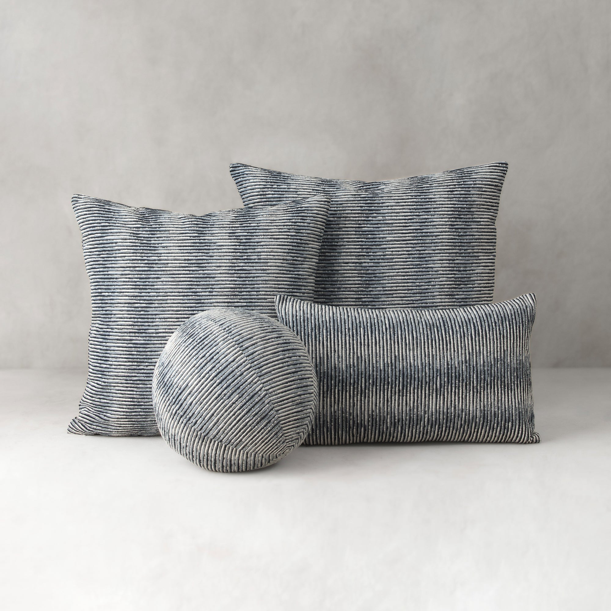 Set of striped cushions on a neutral background