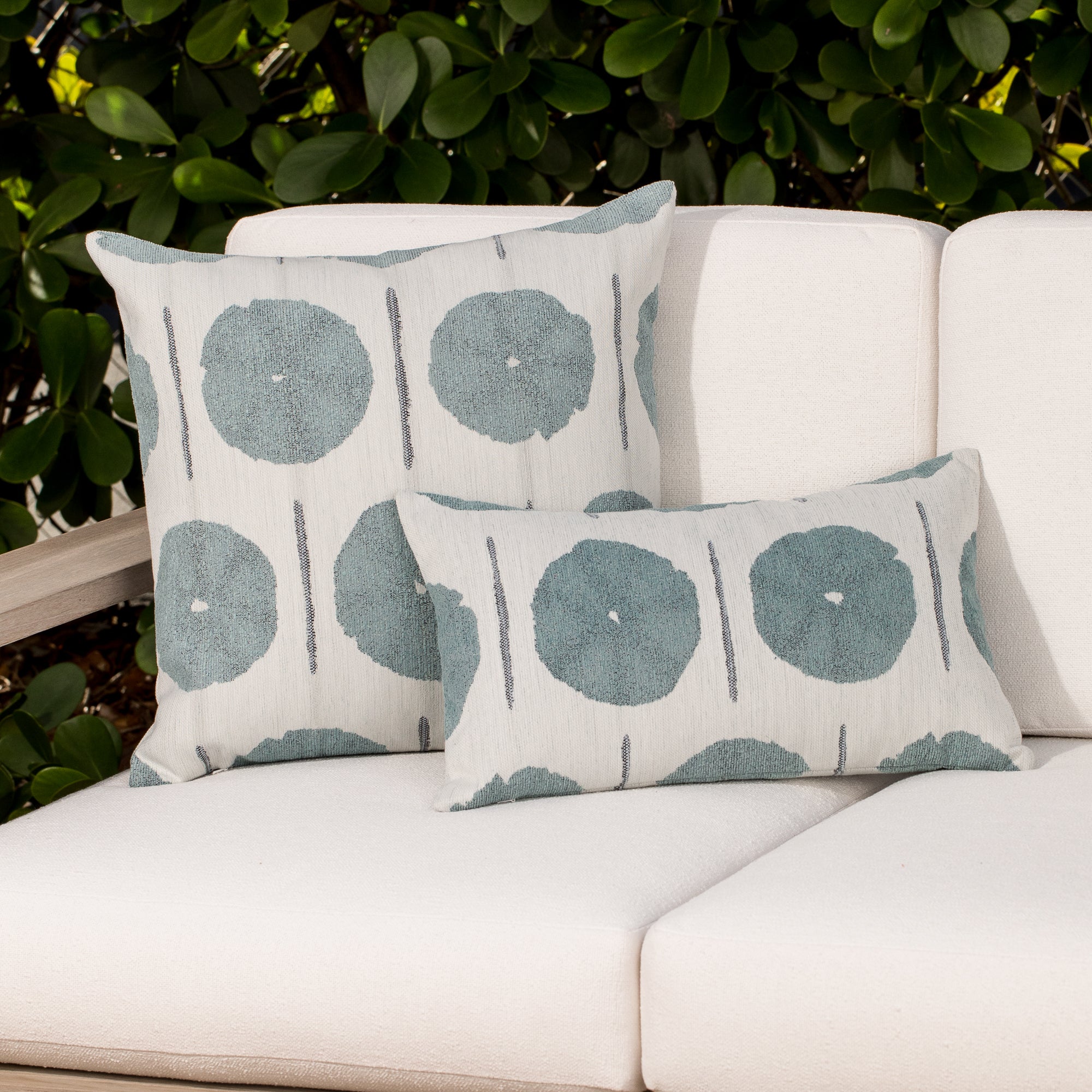 Two decorative pillows with circular pattern on a neutral background