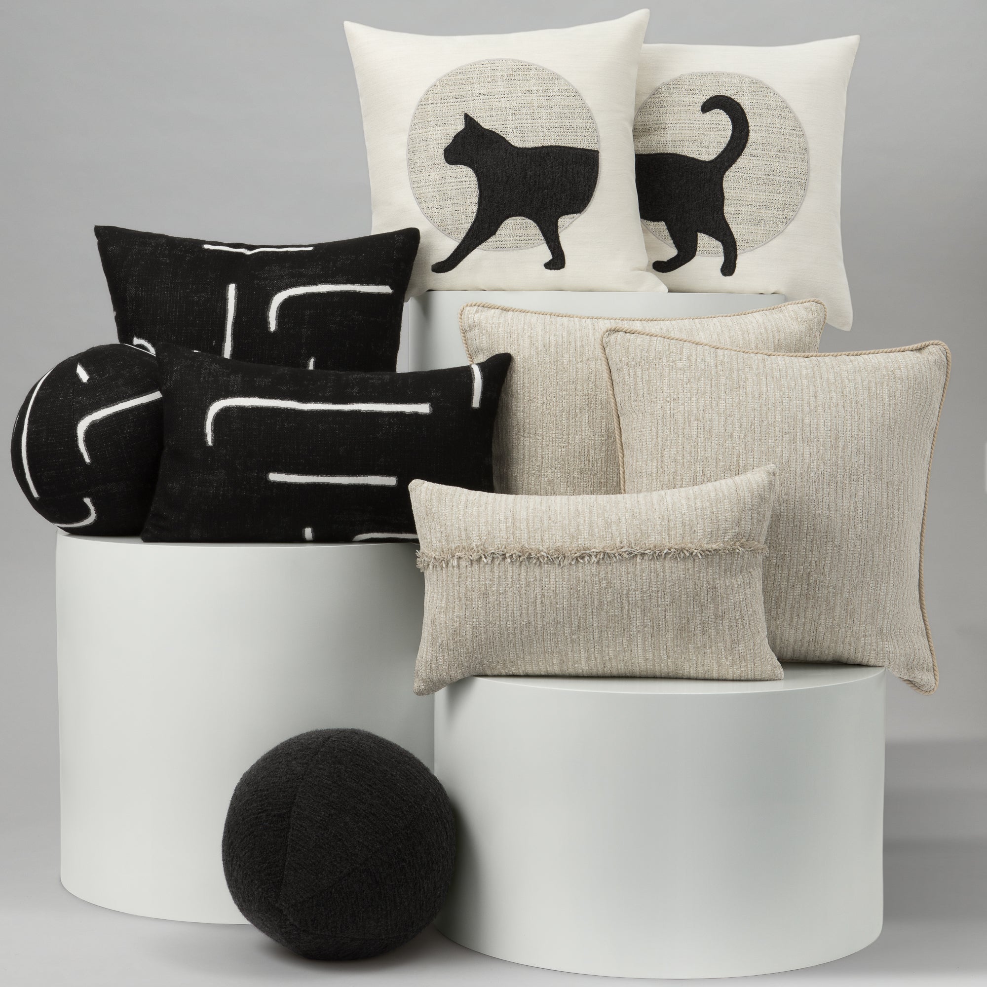 Collection of decorative pillows with various patterns on a gray background