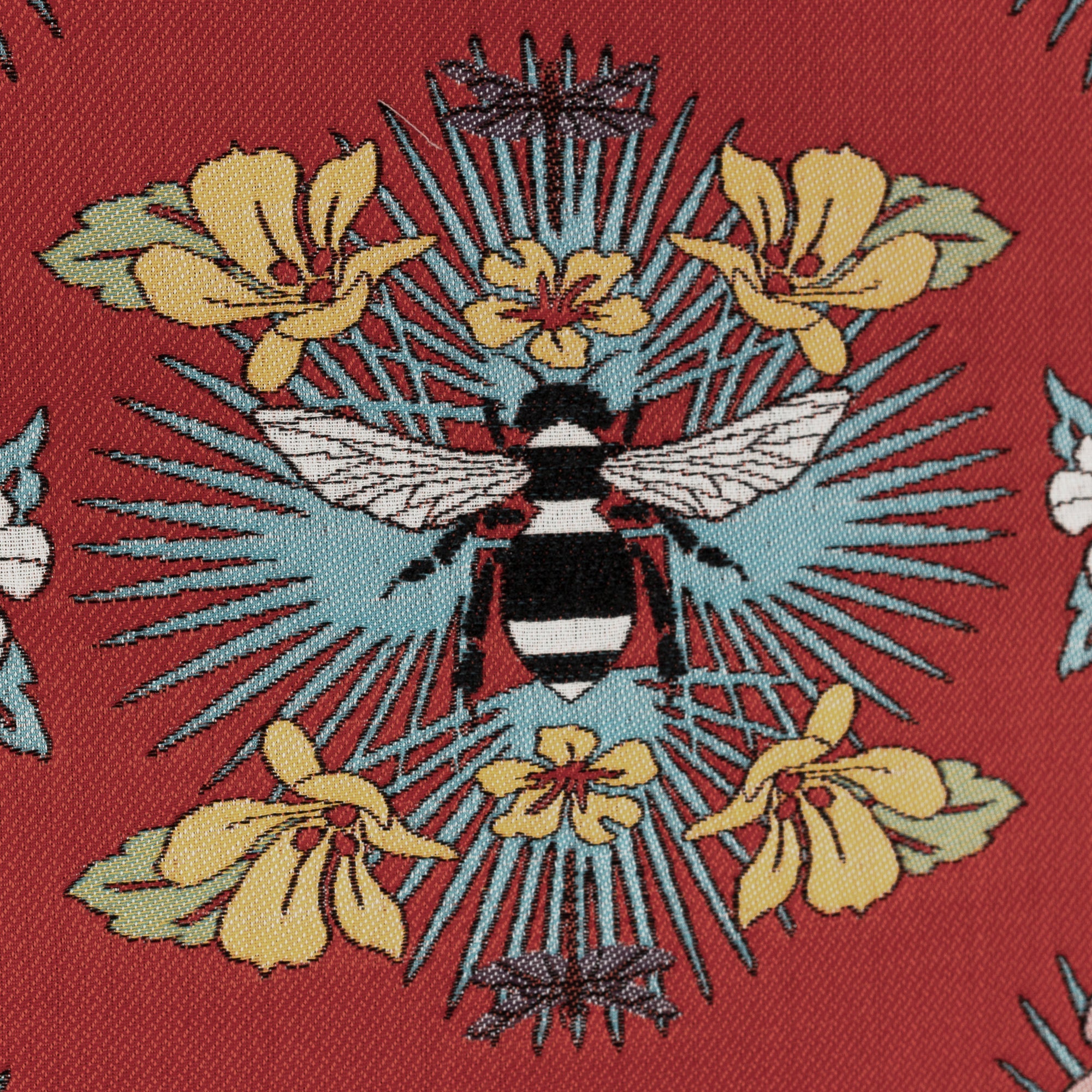 Detail image of Red outdoor safe fabric with tropical bee and floral motif featuring textured yarns and chenille accents