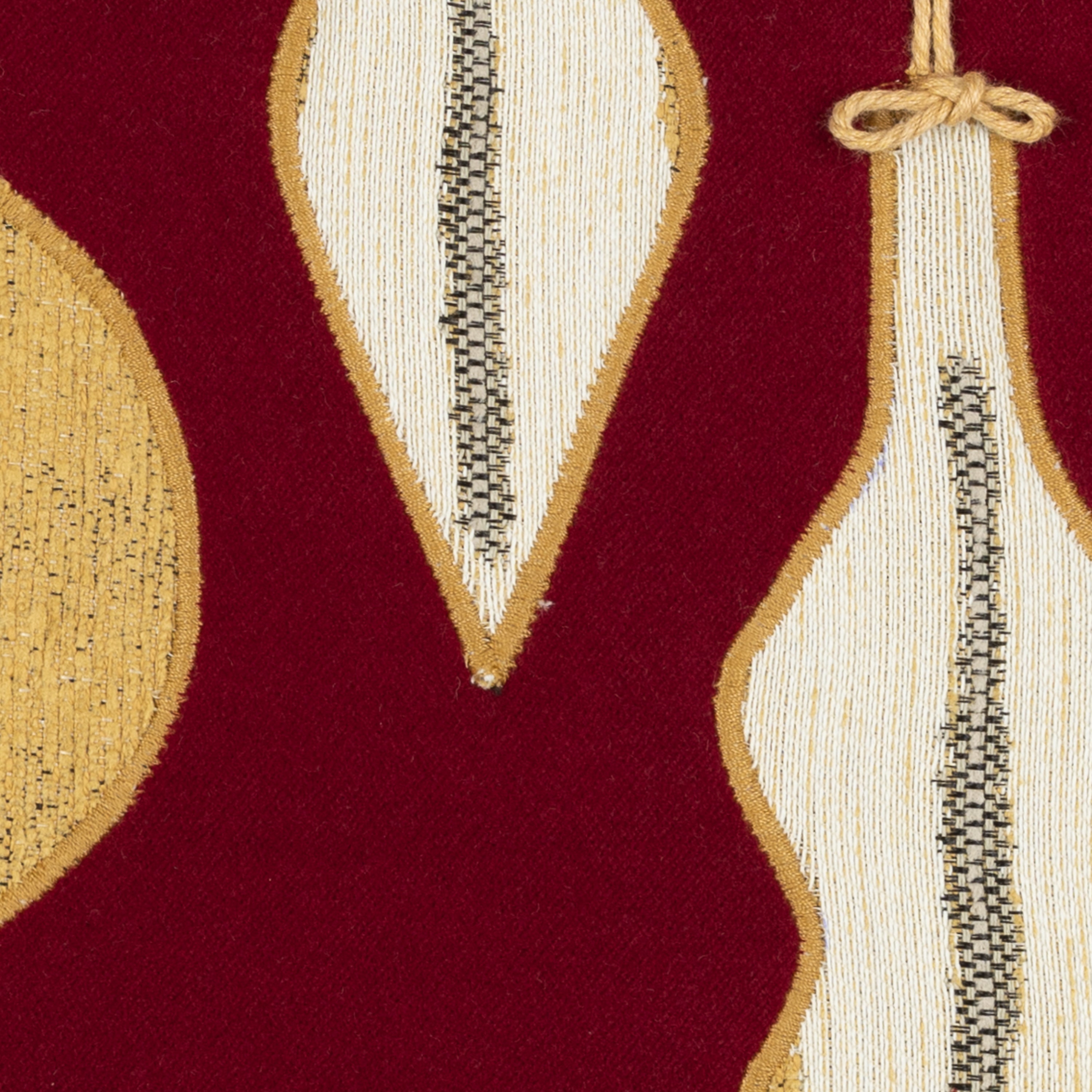 Detail image of Ruby red velvet pillow with gold ornament hand stitched details in square size for holiday and seasonal indoor and outdoor decor